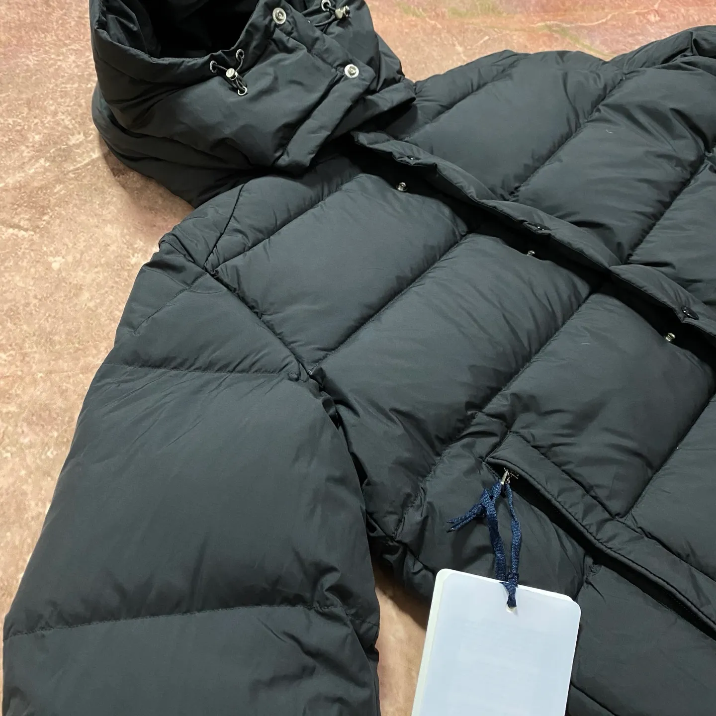 P840 MONCLER matte Maya down jacket. Process description: Made of the brand's iconic longue saison fabric, it has both light texture and excellent thermal insulation performance. This unisex down jacket has a matte appearance and is lined with lon léger brillant material to ensure comfort. Its core filling is 90% high-quality goose down, with a down filling capacity of 204 grams, providing excellent thermal insulation effect. The design continues the classic elements of Moner, with the short silhouette and sleeve patch pocket details paying tribute to the Maya series. In terms of functionality, it is equipped with a detachable and adjustable hood, a dual zipper and snap button opening system, and a zipper pocket to enhance practicality. The sleeves are specially designed with adjustable cuffs and a drawstring hem design, so you can freely adjust the tightness according to your needs. The overall craftsmanship is exquisite, which not only retains Moner's consistent fashion genes, but also enhances the convenience of daily wear through exquisite detail processing. ⚠️Color: Black ⚠️Size: 12345