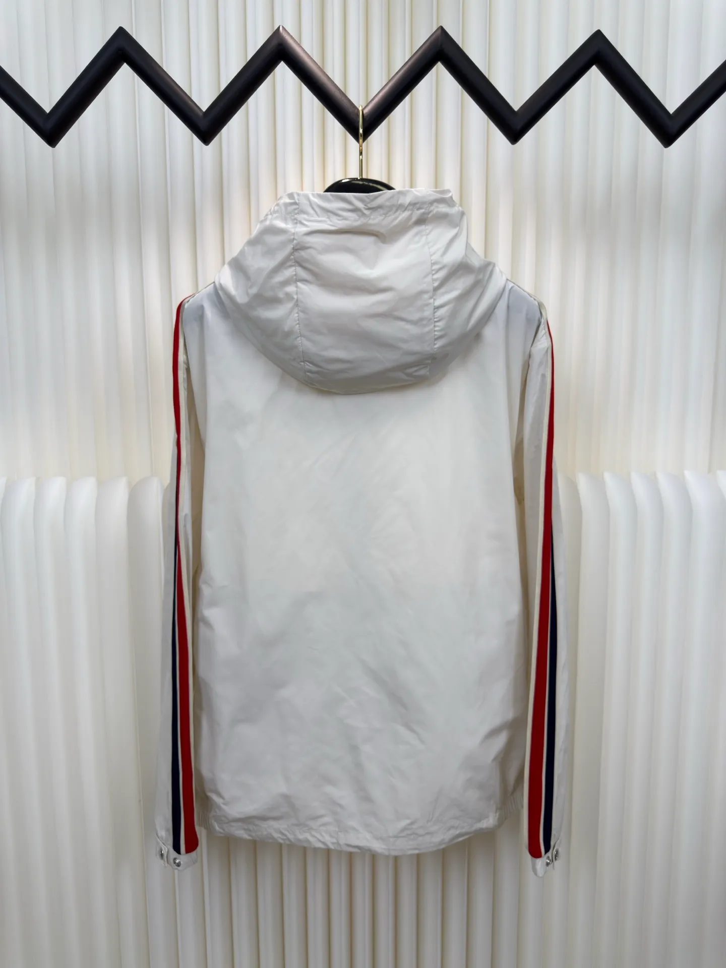 P570 MONCLER lightweight jacket with web trim at the mouth is made of 100% polyester fiber to create a tough protective outer layer. It is famous for its excellent tear resistance and wear resistance. It can quickly return to flatness during wearing and maintain the crisp and stylish appearance of the clothing for a long time. At the same time, it is not easy to deform after being washed for a long time.  Decorative edging in two different colors has been added to the center section of the sleeves. This design element not only adds visual highlights to clothing, making it more fashionable and unique. The webbing is precisely positioned along the cuffs to the seam of the collar and hat to ensure symmetry and overall smoothness. Before actual sewing, use very fine basting stitches for pre-fixing. This step is crucial to prevent the webbing from slipping, twisting, or wrinkling during sewing and ensuring that the final stitch is straight and perfect. Size 1 2 3 4