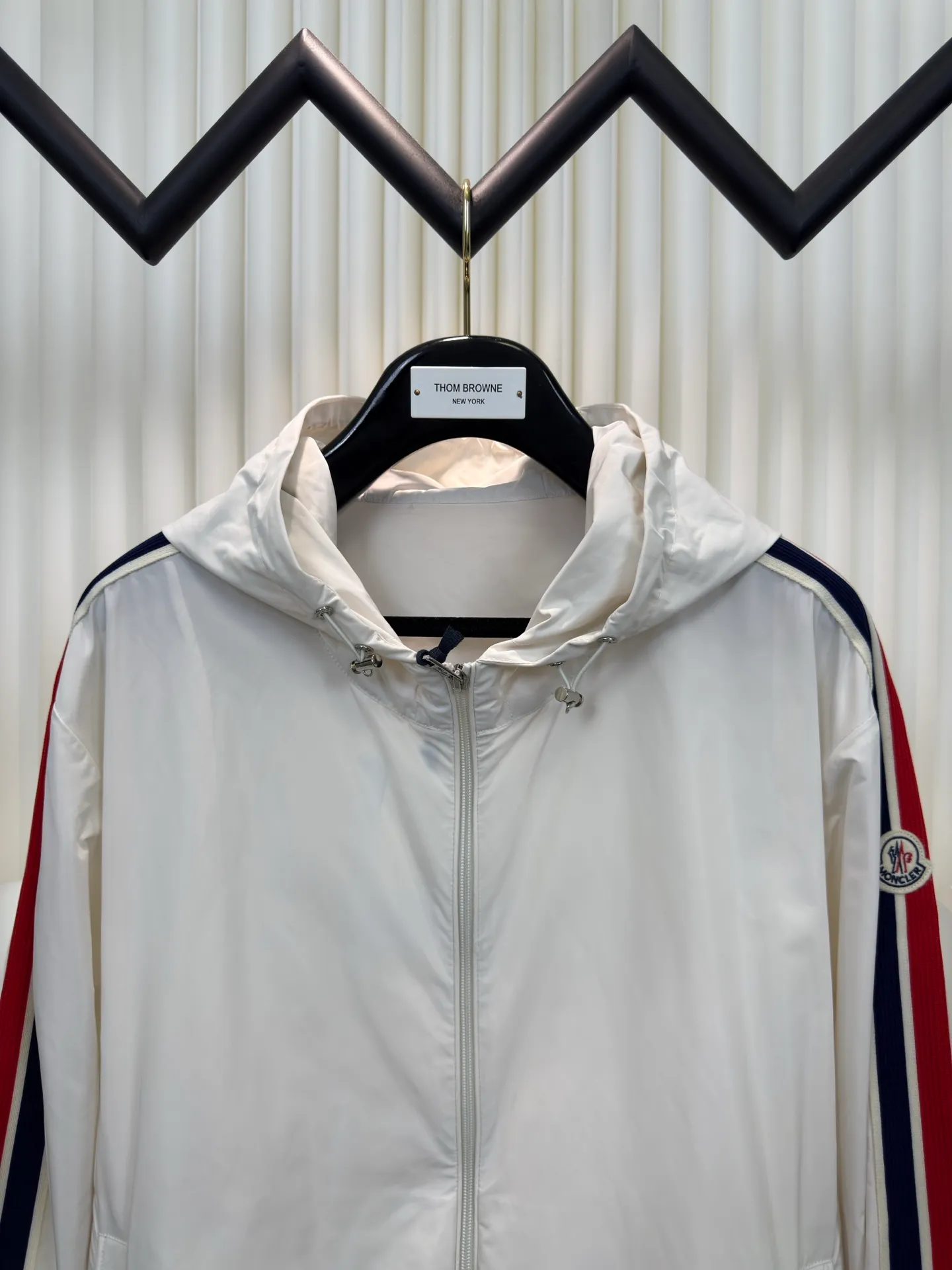 P570 MONCLER lightweight jacket with web trim at the mouth is made of 100% polyester fiber to create a tough protective outer layer. It is famous for its excellent tear resistance and wear resistance. It can quickly return to flatness during wearing and maintain the crisp and stylish appearance of the clothing for a long time. At the same time, it is not easy to deform after being washed for a long time.  Decorative edging in two different colors has been added to the center section of the sleeves. This design element not only adds visual highlights to clothing, making it more fashionable and unique. The webbing is precisely positioned along the cuffs to the seam of the collar and hat to ensure symmetry and overall smoothness. Before actual sewing, use very fine basting stitches for pre-fixing. This step is crucial to prevent the webbing from slipping, twisting, or wrinkling during sewing and ensuring that the final stitch is straight and perfect. Size 1 2 3 4