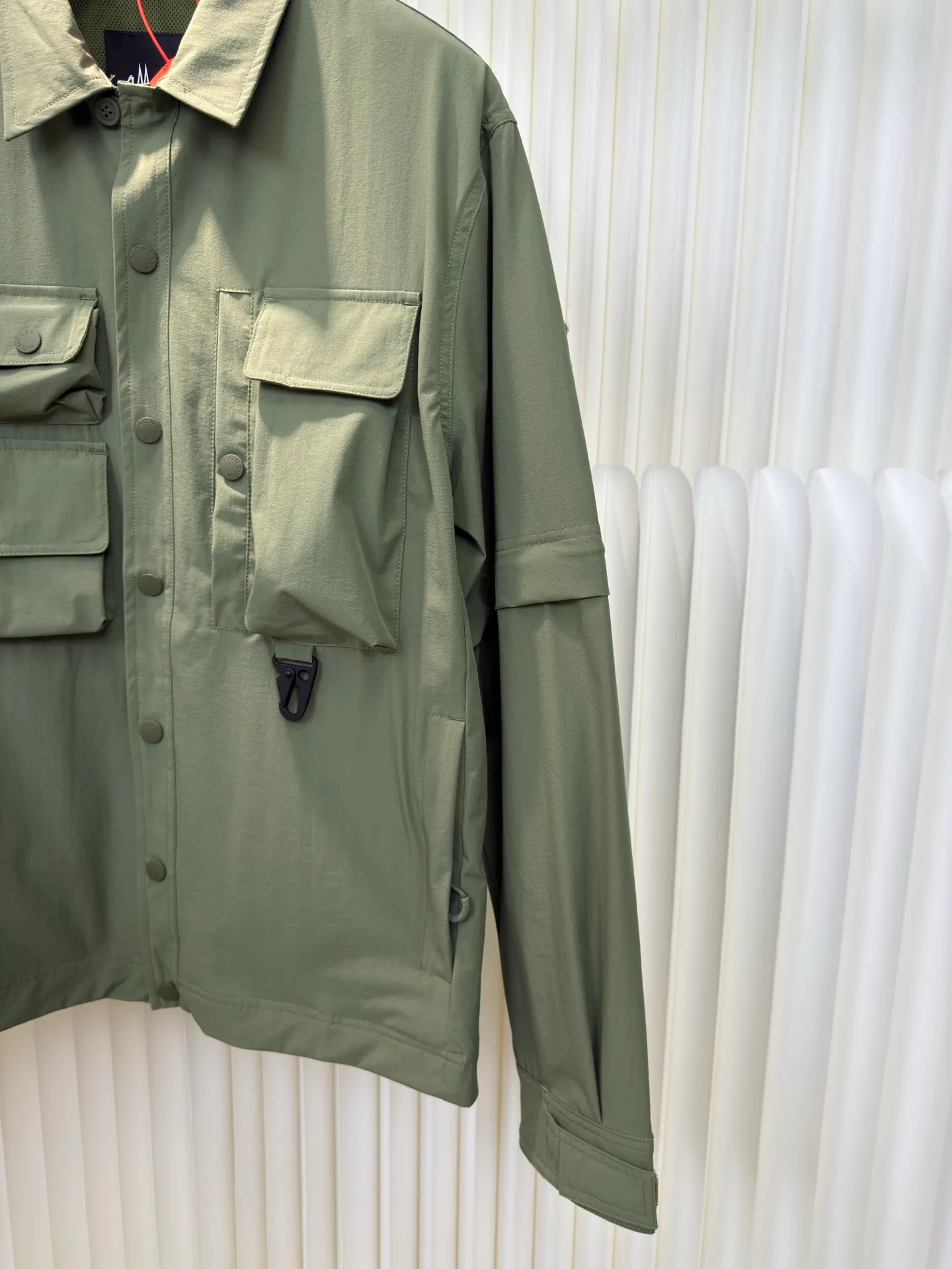 P640 Moncler Grenoble Functional Outdoor Jacket Custom-dyed double-stretch mercerized poplin Custom-dyed soft-mesh pongee Excellent texture Comfortable and close to the skin Dark green inspired by plant texture The color is taken from sage leaves soaked in morning dew Precision narrative of functional pocket system Balance of function and aesthetics The iconic Moncler logo appears on the sleeves, fully recognizable The triangular logo of the same color is hidden in the fabric texture like a mark in the undercurrent of the deep sea Extremely hidden and visible. The detachable sleeve design allows for diversified outfits. You can switch styles at will. Feel free and elegant. Show your dignity. Balance outdoor practicality and urban aesthetics. Lead the fashion. Adopt three-in-one process. Give priority to evenly coating the glue on the surface of the substrate that needs to be composited. Then dry and solidify. Then laminate the substrate with the adhesive film and the non-woven fabric. Then cool and solidify. Then composite the filter non-woven fabric. The workmanship is cumbersome and complex. Time-consuming and labor-intensive. Embossed composite technology Through computer scanning, ensure that the imprint size and shape are consistent with the original. Then use special glue as an adhesive to combine and then solidify to achieve complete dryness and the best bonding effect. Use CNC laser burning and cutting based on the high-energy characteristics of the laser. Precisely control the movement path of the laser beam with a laser generator to achieve precise cutting of the shape of the piece. Template machine bag opening. The preset template guides the position, shape and size of the bag opening. The accuracy ensures the quality of the bag opening effect. Uses infrared special machine to fasten the position more accurately. Strong and sturdy, loose fit, detachable sleeve splicing, style can be switched at will Size: 1 2 3 4