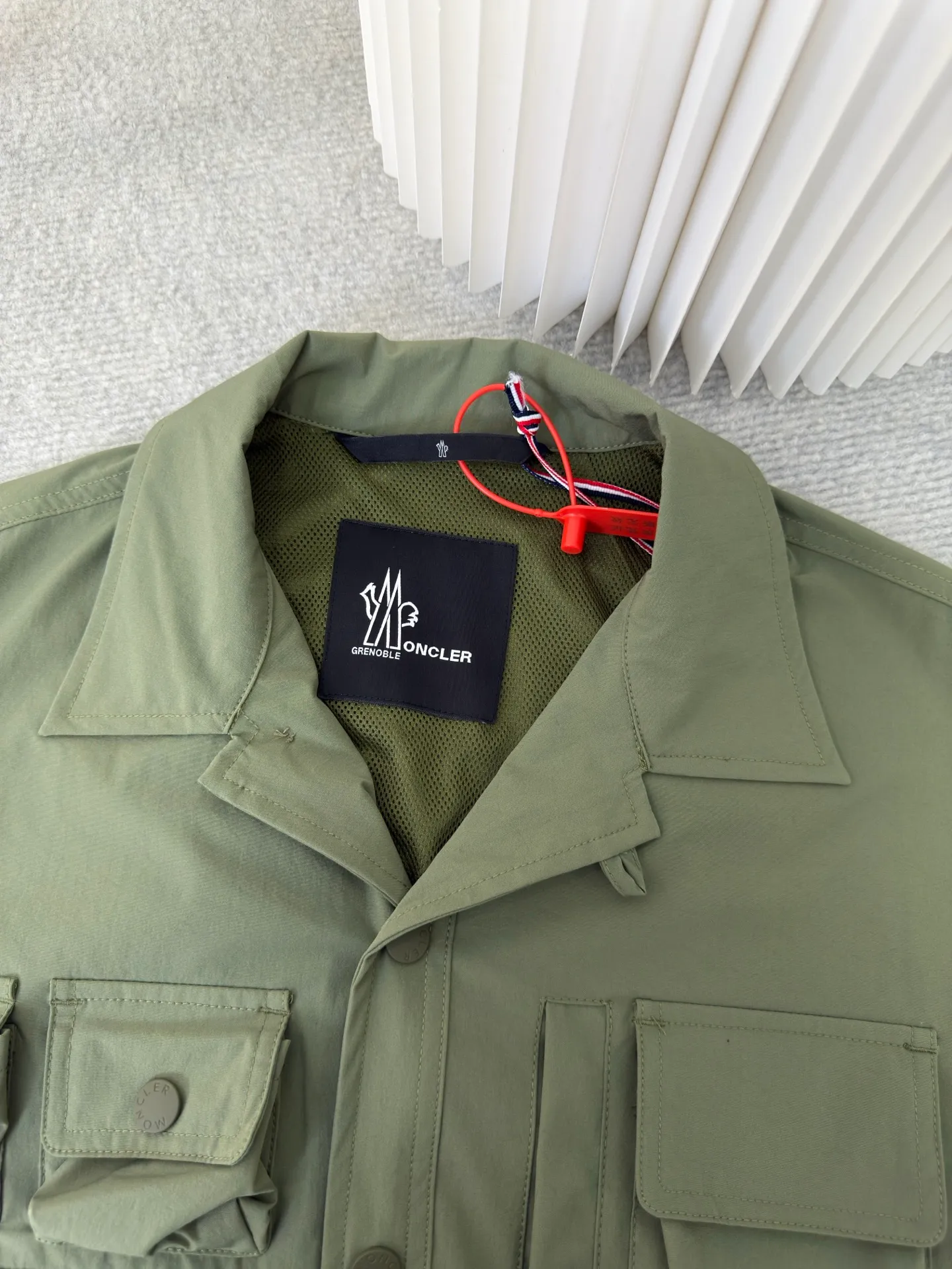 P640 Moncler Grenoble Functional Outdoor Jacket Custom-dyed double-stretch mercerized poplin Custom-dyed soft-mesh pongee Excellent texture Comfortable and close to the skin Dark green inspired by plant texture The color is taken from sage leaves soaked in morning dew Precision narrative of functional pocket system Balance of function and aesthetics The iconic Moncler logo appears on the sleeves, fully recognizable The triangular logo of the same color is hidden in the fabric texture like a mark in the undercurrent of the deep sea Extremely hidden and visible. The detachable sleeve design allows for diversified outfits. You can switch styles at will. Feel free and elegant. Show your dignity. Balance outdoor practicality and urban aesthetics. Lead the fashion. Adopt three-in-one process. Give priority to evenly coating the glue on the surface of the substrate that needs to be composited. Then dry and solidify. Then laminate the substrate with the adhesive film and the non-woven fabric. Then cool and solidify. Then composite the filter non-woven fabric. The workmanship is cumbersome and complex. Time-consuming and labor-intensive. Embossed composite technology Through computer scanning, ensure that the imprint size and shape are consistent with the original. Then use special glue as an adhesive to combine and then solidify to achieve complete dryness and the best bonding effect. Use CNC laser burning and cutting based on the high-energy characteristics of the laser. Precisely control the movement path of the laser beam with a laser generator to achieve precise cutting of the shape of the piece. Template machine bag opening. The preset template guides the position, shape and size of the bag opening. The accuracy ensures the quality of the bag opening effect. Uses infrared special machine to fasten the position more accurately. Strong and sturdy, loose fit, detachable sleeve splicing, style can be switched at will Size: 1 2 3 4