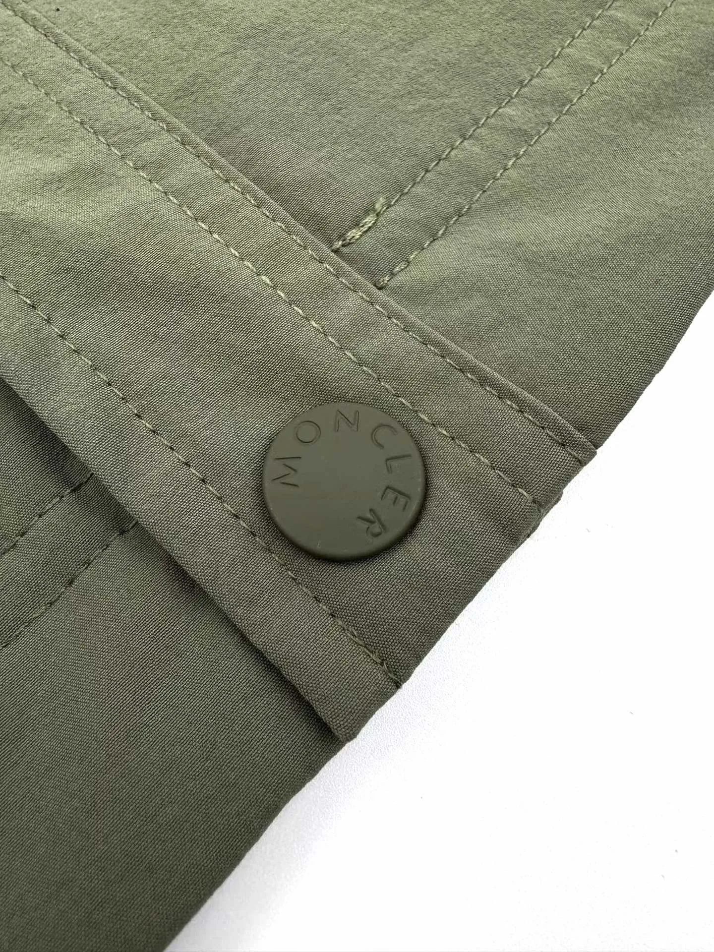 P610 Moncler Grenoble functional outdoor jacket Custom-dyed double-stretch mercerized poplin Custom-dyed soft mesh pongee Excellent texture Comfortable and close to the skin Dark green inspired by plant texture The color is taken from sage leaves soaked in morning dew Precision narrative of functional pocket system Balance of function and aesthetics The iconic Moncler logo appears on the sleeves for full recognition The triangular logo of the same color is hidden in the fabric texture like a mark in the undercurrent of the deep sea, extremely invisible and yet obvious The detachable sleeve design allows for diversified outfits. You can switch styles at will. It is chic and free, showing nobility. It balances outdoor practicality and urban aesthetics and leads the fashion. Process 1: Adopt a three-in-one process. Prioritize and evenly coat the glue on the surface of the substrate that needs to be composited, and then dry and solidify it. Then laminate the substrate with the adhesive film and the non-woven fabric, then cool and solidify, and then composite it with the filter non-woven fabric. The workmanship is cumbersome and complex, time-consuming and labor-intensive. Process 2: Embossing composite technology uses computer scanning to ensure that the imprint size and shape are consistent with the original, and then uses special glue as an adhesive to combine and solidify to achieve complete dryness and the best bonding effect. Process 3: Use CNC laser burning and cutting. Based on the high-energy characteristics of the laser, the moving path of the laser beam is precisely controlled by the laser generator to achieve precise cutting of the shape of the piece. Process 4: Template machine bag opening. The preset template guides the position, shape and size of the bag opening. The accuracy ensures the quality of the bag opening effect. Process 5: Using infrared special machine buttoning, the position is more precise and strong. Accessories: Customized 1:1 Moncler snap button Customized 1:1 Moncler resin buckle Customized 1:1 Moncler logo seal Customized 1:1 Moncler logo armband Customized 1:1 Moncler zipper rope ring Customized 1:1 Moncler zipper pull Customized 1:1 Moncler trademark Version: Loose version Function: Detachable sleeve splicing Style can be switched at will Size: 1 2 3 4