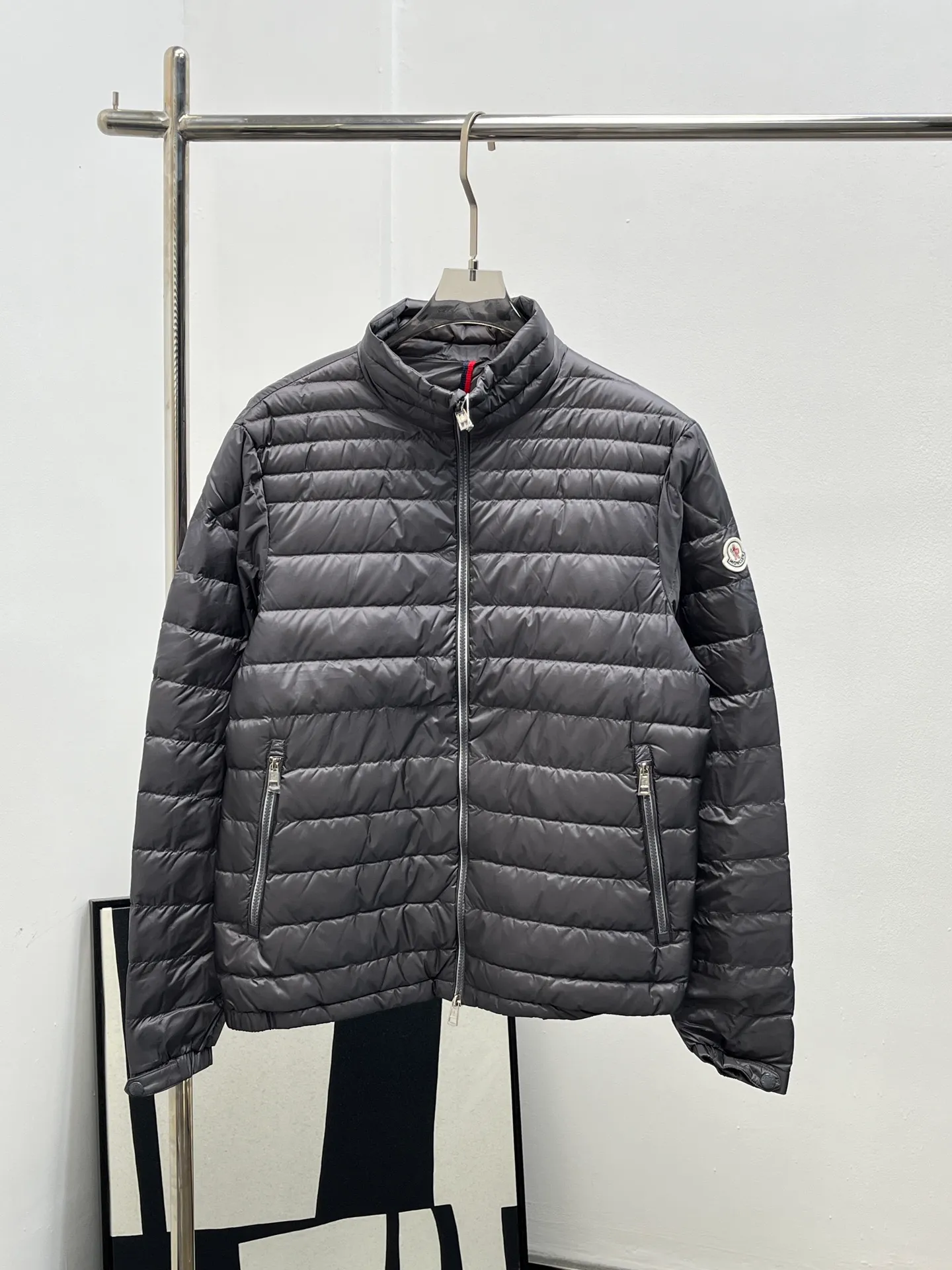 P920 25Moncler *Arnique men's short down is light and thin. Arnique short down is light and warm and made of longue saison fabric. This functional nylon fabric provides warmth without being bulky. This style is finished with quilting in varying sized squares, which helps give it a lightweight texture. The classic fit design can be easily paired with urban casual wear or as sports wear for outdoor activities. Color: black gray