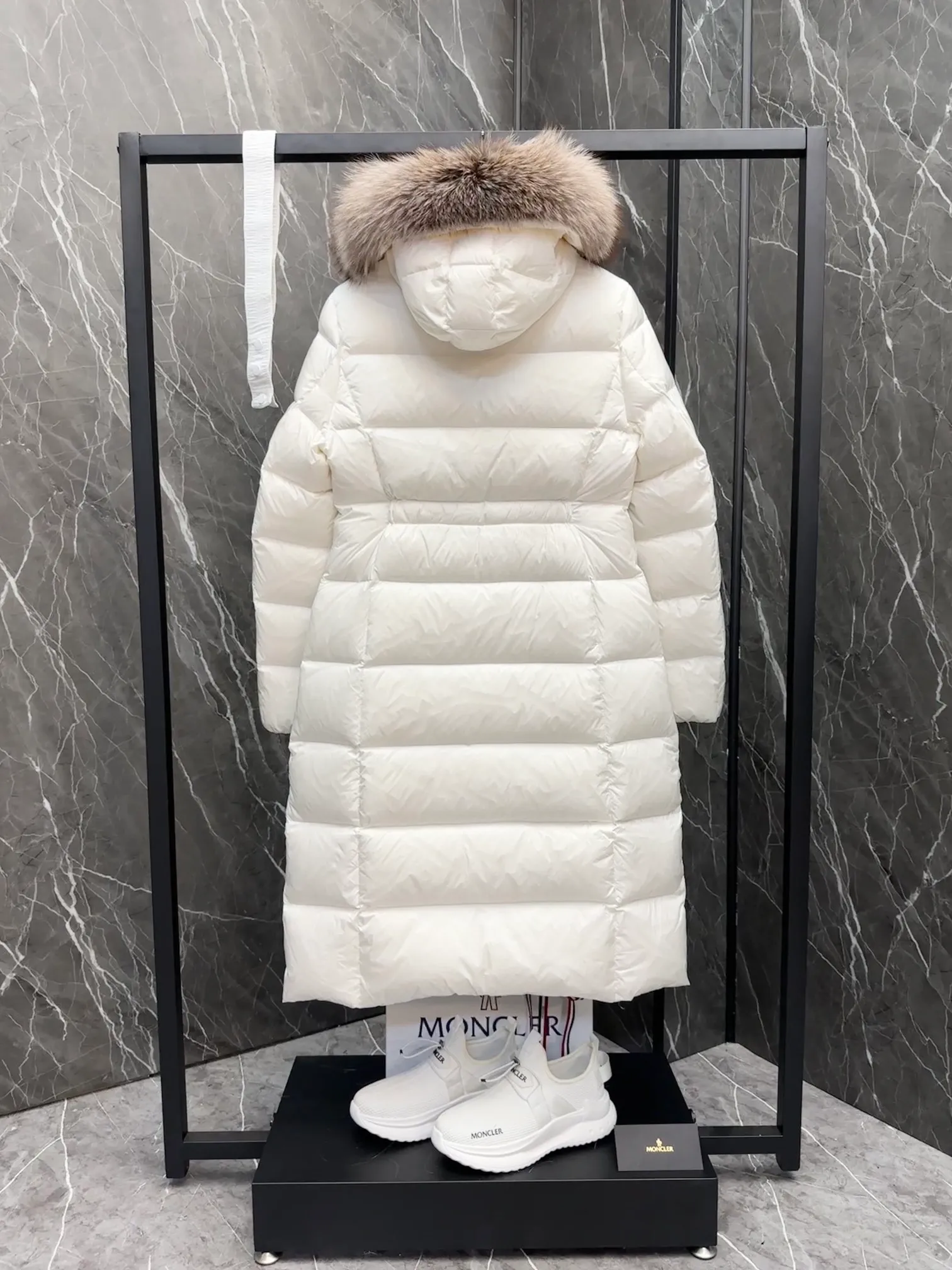P1020 Moncler Boedic long down jacket for women. (Classic fox fur collar) adopts a whole fox fur collar imported from Finland. The Boedic long down jacket combines exquisite materials and attention to details. The timeless and elegant fashion design can provide you with a warm and caring wearing experience.  Boedic's long down jacket features a waist-cinching belt to accentuate its feminine silhouette for a stylish winter look. The cozy hood has rich fleece trim and is easily removable to suit your mood and weather conditions. Details •Made from lounge saison fabric •Longue saison lining •Filled with down •Hood with removable fox fur collar trim •Two-way zip closure •Elastic waistband with snap button closure •Zip pockets with grosgrain detail •Elastic cuffs Size : 1-4