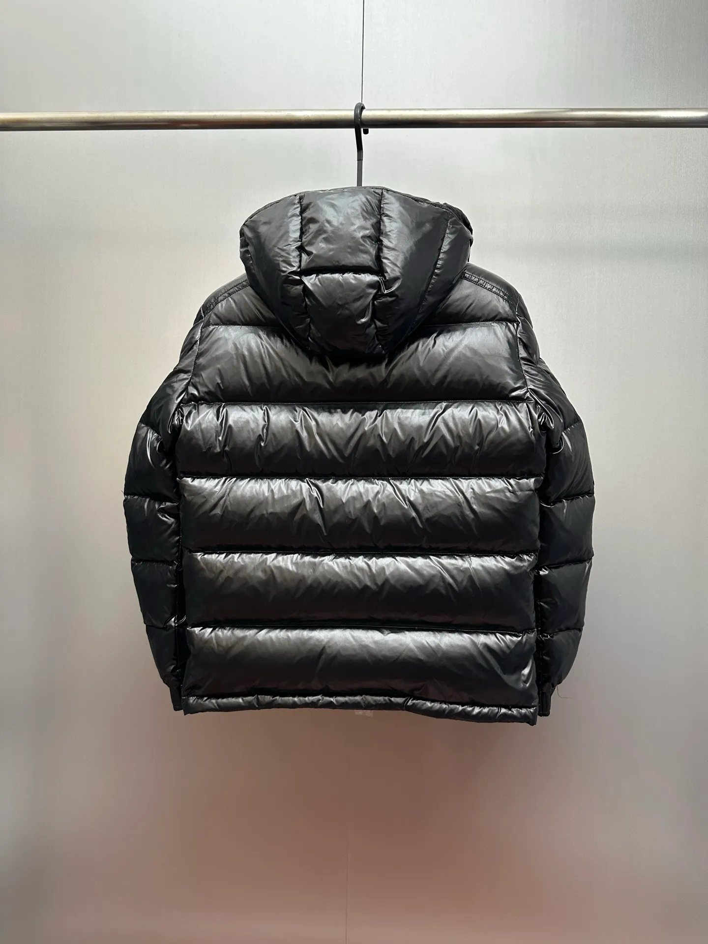 P1040 Premium down ⬆️ Moncler Maya short men's down jacket jacket. Classic Maya (latest purchase counter 2025) The latest classic fabrics are on sale at the counter. ⚠️Maya is a classic series at the counter. Every year there are minor changes. Change the soup without changing the medicine. Not to save development costs, only the latest and best. The Moncler Maya short down jacket is a classic Moncler item, with a highly recognizable style. Made of lacquered nylon and available in many colors, it is a fashionable item for casual commuting and a popular product.  The Moncler Maya men's down jacket in shiny patent nylon with signature rectangular quilting is the epitome of Moncler style. A classic cropped design that transcends seasons and styles, it features a statement silhouette, removable hood and adjustable hem. The cuffs are embellished with classic patch pockets, showcasing the brand's signature style. Details •Made from patented nylon •Painted nylon lining •Down-filled, rectangular quilting •Detachable hood with snap fastening and drawstring adjustment •Two-way zip fly •Exterior and internal zippered pockets •Adjustable elastic cuffs with press-stud •Drawstring at hood •Flap patch pockets at sleeves •Moncler felt logo on sleeves Exclusive quality, hanging at home, five-layer anti-counterfeiting verification, NFC armband chip identification ➕NFC label washing chip identification ➕Elevator scan code verification ➕Washing label scan code verification ➕tag electronic anti-counterfeiting verification❗️❗️❗️ Color: Black Size: 1-6. Couple style
