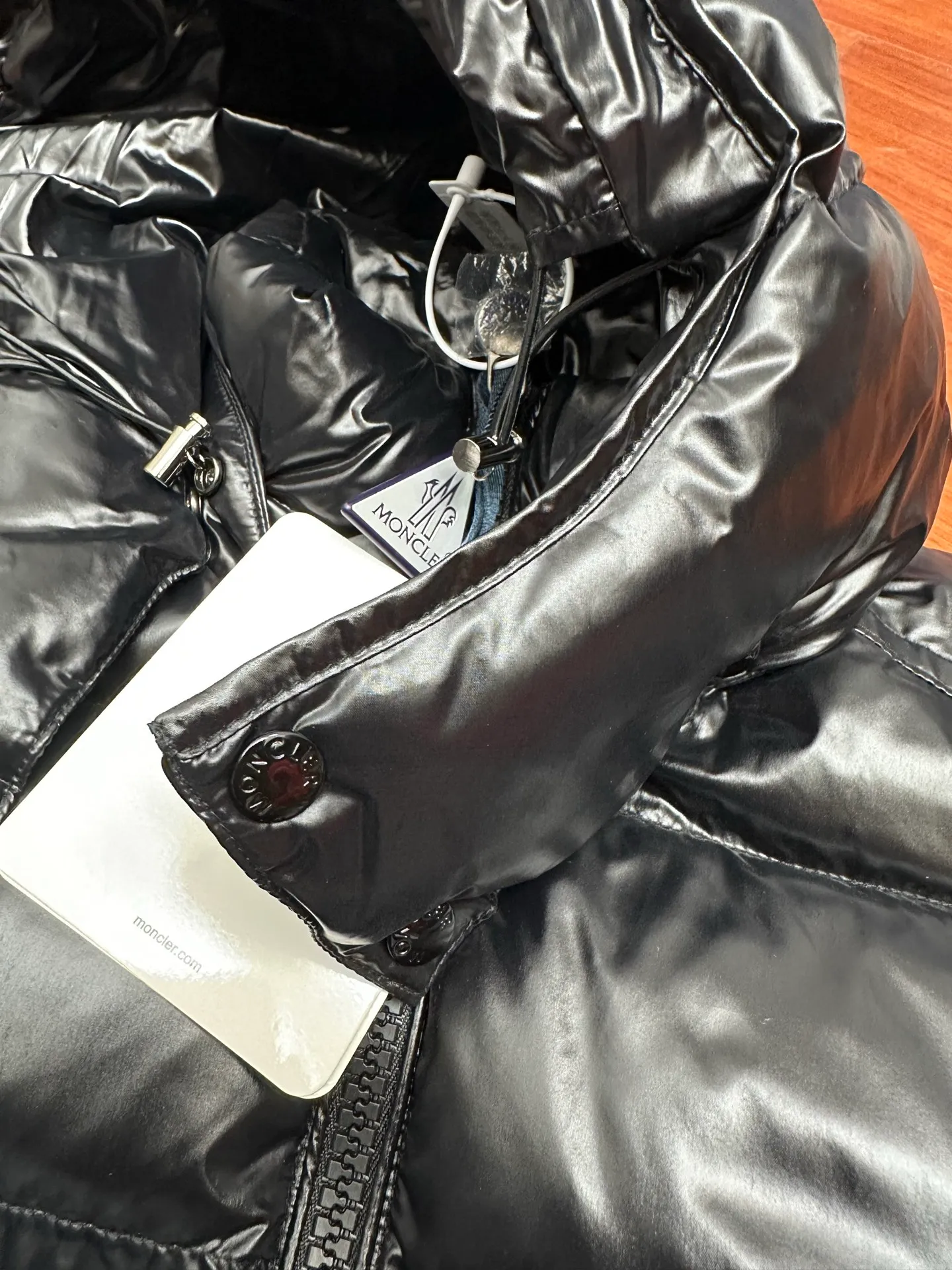 P1040 Premium down ⬆️ Moncler Maya short men's down jacket jacket. Classic Maya (latest purchase counter 2025) The latest classic fabrics are on sale at the counter. ⚠️Maya is a classic series at the counter. Every year there are minor changes. Change the soup without changing the medicine. Not to save development costs, only the latest and best. The Moncler Maya short down jacket is a classic Moncler item, with a highly recognizable style. Made of lacquered nylon and available in many colors, it is a fashionable item for casual commuting and a popular product.  The Moncler Maya men's down jacket in shiny patent nylon with signature rectangular quilting is the epitome of Moncler style. A classic cropped design that transcends seasons and styles, it features a statement silhouette, removable hood and adjustable hem. The cuffs are embellished with classic patch pockets, showcasing the brand's signature style. Details •Made from patented nylon •Painted nylon lining •Down-filled, rectangular quilting •Detachable hood with snap fastening and drawstring adjustment •Two-way zip fly •Exterior and internal zippered pockets •Adjustable elastic cuffs with press-stud •Drawstring at hood •Flap patch pockets at sleeves •Moncler felt logo on sleeves Exclusive quality, hanging at home, five-layer anti-counterfeiting verification, NFC armband chip identification ➕NFC label washing chip identification ➕Elevator scan code verification ➕Washing label scan code verification ➕tag electronic anti-counterfeiting verification❗️❗️❗️ Color: Black Size: 1-6. Couple style