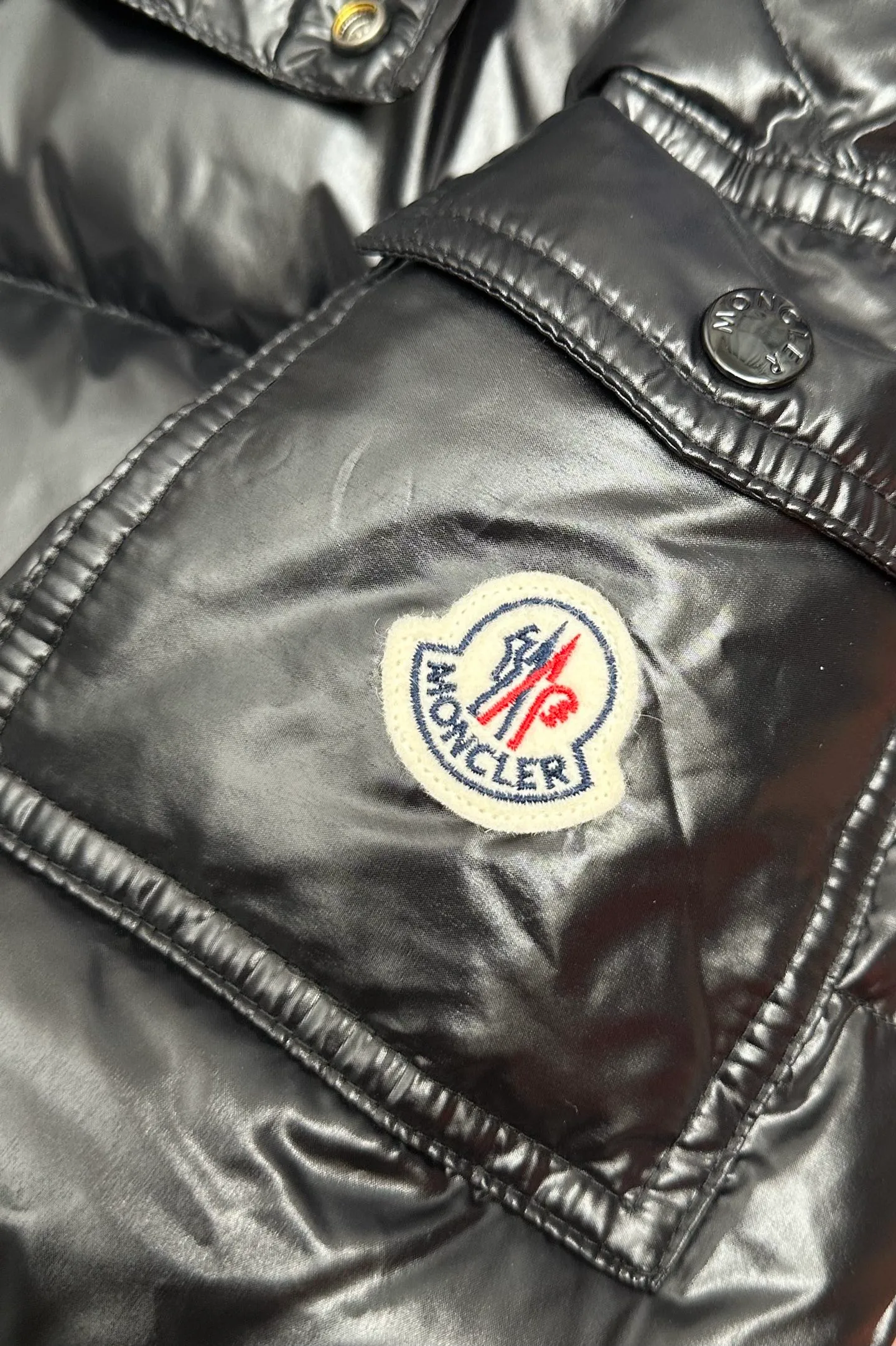 P1040 Premium down ⬆️ Moncler Maya short men's down jacket jacket. Classic Maya (latest purchase counter 2025) The latest classic fabrics are on sale at the counter. ⚠️Maya is a classic series at the counter. Every year there are minor changes. Change the soup without changing the medicine. Not to save development costs, only the latest and best. The Moncler Maya short down jacket is a classic Moncler item, with a highly recognizable style. Made of lacquered nylon and available in many colors, it is a fashionable item for casual commuting and a popular product.  The Moncler Maya men's down jacket in shiny patent nylon with signature rectangular quilting is the epitome of Moncler style. A classic cropped design that transcends seasons and styles, it features a statement silhouette, removable hood and adjustable hem. The cuffs are embellished with classic patch pockets, showcasing the brand's signature style. Details •Made from patented nylon •Painted nylon lining •Down-filled, rectangular quilting •Detachable hood with snap fastening and drawstring adjustment •Two-way zip fly •Exterior and internal zippered pockets •Adjustable elastic cuffs with press-stud •Drawstring at hood •Flap patch pockets at sleeves •Moncler felt logo on sleeves Exclusive quality, hanging at home, five-layer anti-counterfeiting verification, NFC armband chip identification ➕NFC label washing chip identification ➕Elevator scan code verification ➕Washing label scan code verification ➕tag electronic anti-counterfeiting verification❗️❗️❗️ Color: Black Size: 1-6. Couple style
