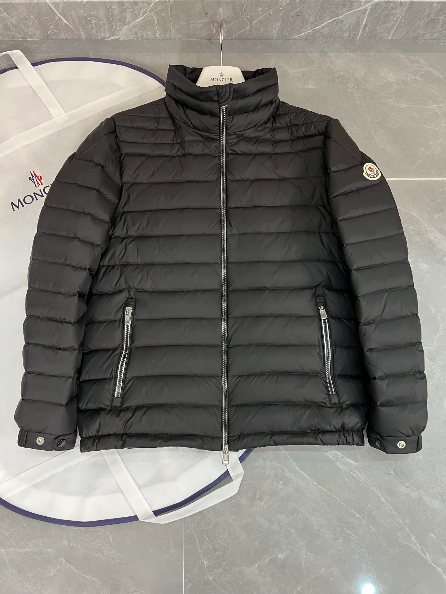 The P780 Arnique hooded down jacket with polyester outer fabric is Moncler's classic men's design.