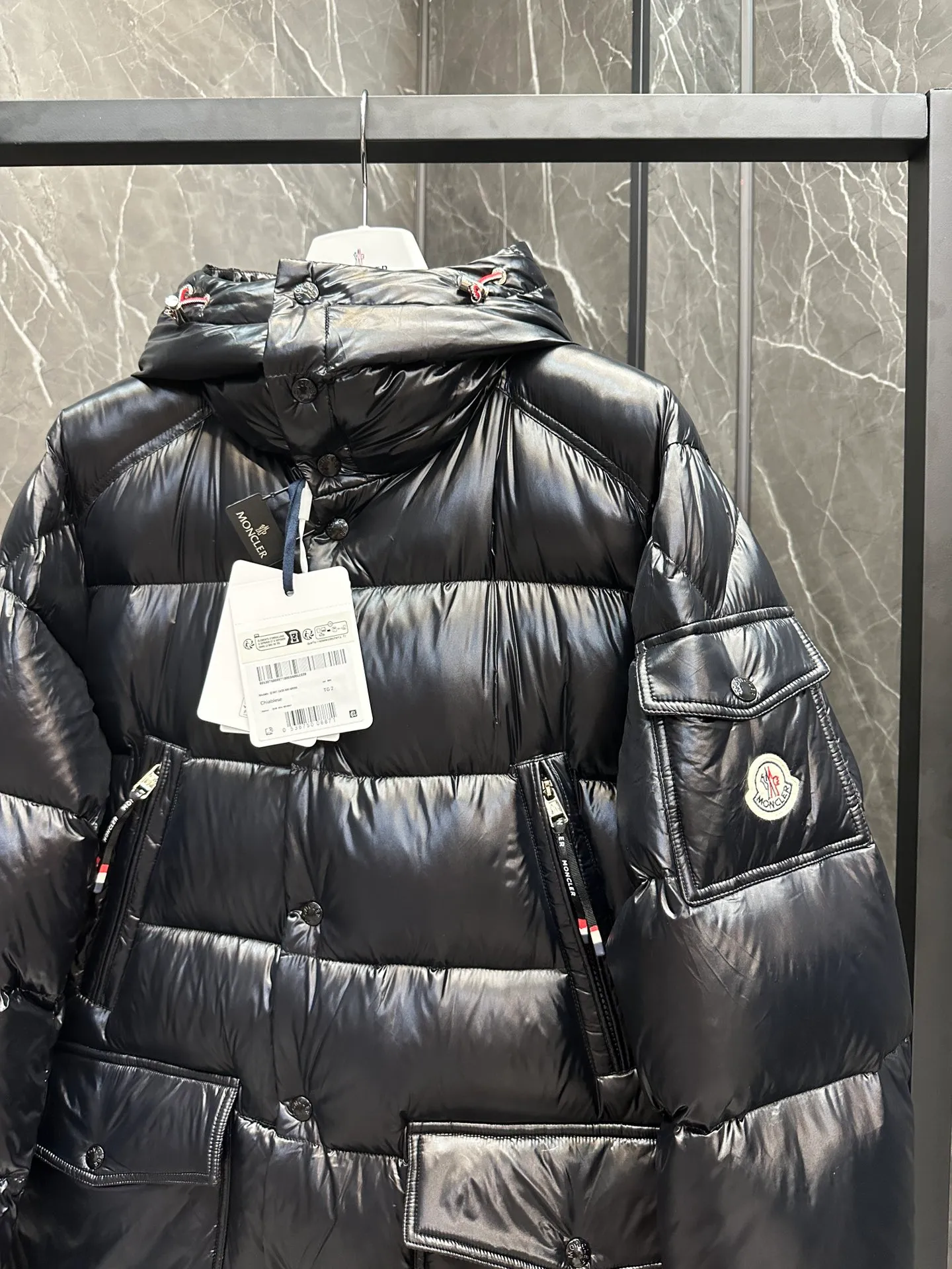 P1460 Premium down⬆️Moncler Chiablese classic style, mid-length down jacket. The Chiablese mid-length down jacket is a model of Moncler. It is made of lacquered nylon and is recommended for wear.  In keeping with the brand's sustainability initiative, the Chiablese hooded down jacket is made from patented nylon. It's embellished with subtle tricolor details and signature patch pockets on the sleeves, adding to Moncler's chic style. Details • Made of nylon laqué fabric • Nylon laqué lining • Filled down • Adjustable hood • Zipper and snap closure • Zippered chest pocket • Snap snap closure • Adjustable cuffs • Adjustable three-color elastic drawstring waist Size : 1-5 Couple size. D9893068830
