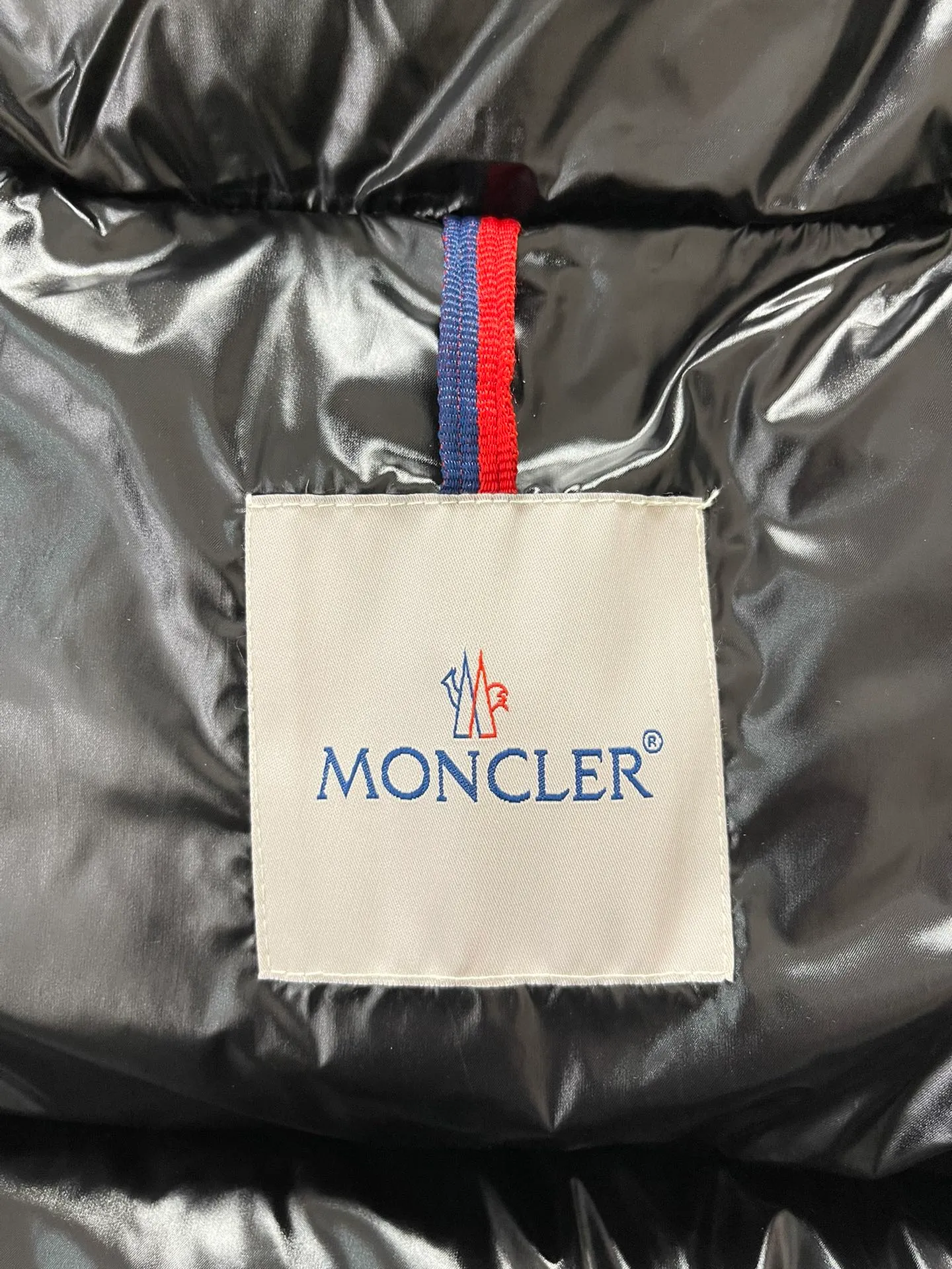 P1180 Moncler Montbeliard glossy down jacket The Montbeliard down jacket is made of shiny patent nylon and features highly recognizable rectangular quilting. Featuring a hooded design and signature patch pocket at chest.  Fabric: 100% nylon Filling content: 90% white goose down 250-300g Craftsmanship: Made of nylon laqué fabric Nylon laque lining Filled with down, detachable and adjustable hood with drawstring closure Built-in flap with webbing, black pocket details at the lower end Zipper closure Collar with snap buttons Zipper pockets Patch pockets with snap buttons Adjustable cuffs Adjustable elastic drawstring hem.  Size: 1 2 3 4 5 0548000