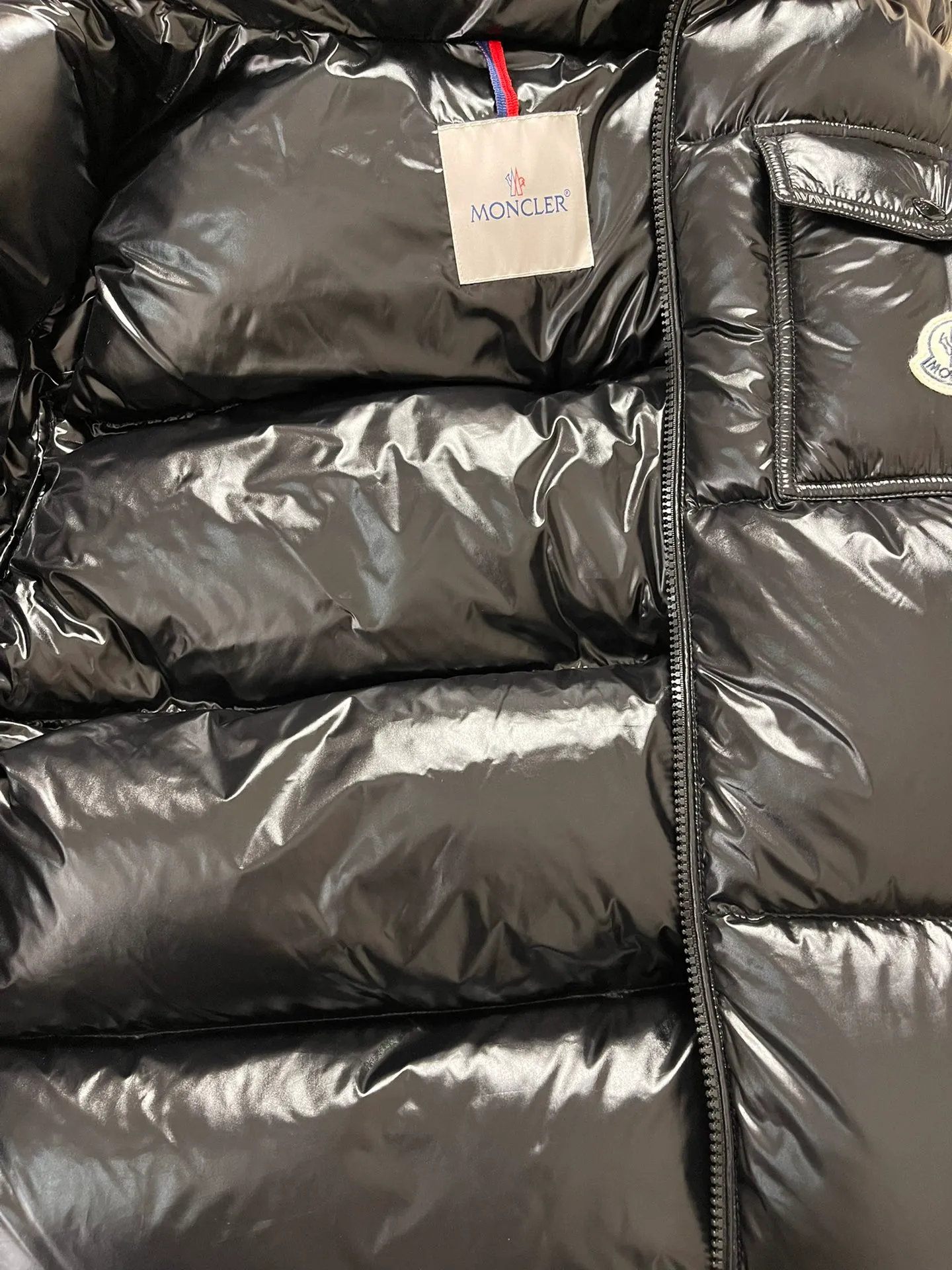 P1180 Moncler Montbeliard glossy down jacket The Montbeliard down jacket is made of shiny patent nylon and features highly recognizable rectangular quilting. Featuring a hooded design and signature patch pocket at chest.  Fabric: 100% nylon Filling content: 90% white goose down 250-300g Craftsmanship: Made of nylon laqué fabric Nylon laque lining Filled with down, detachable and adjustable hood with drawstring closure Built-in flap with webbing, black pocket details at the lower end Zipper closure Collar with snap buttons Zipper pockets Patch pockets with snap buttons Adjustable cuffs Adjustable elastic drawstring hem.  Size: 1 2 3 4 5 0548000
