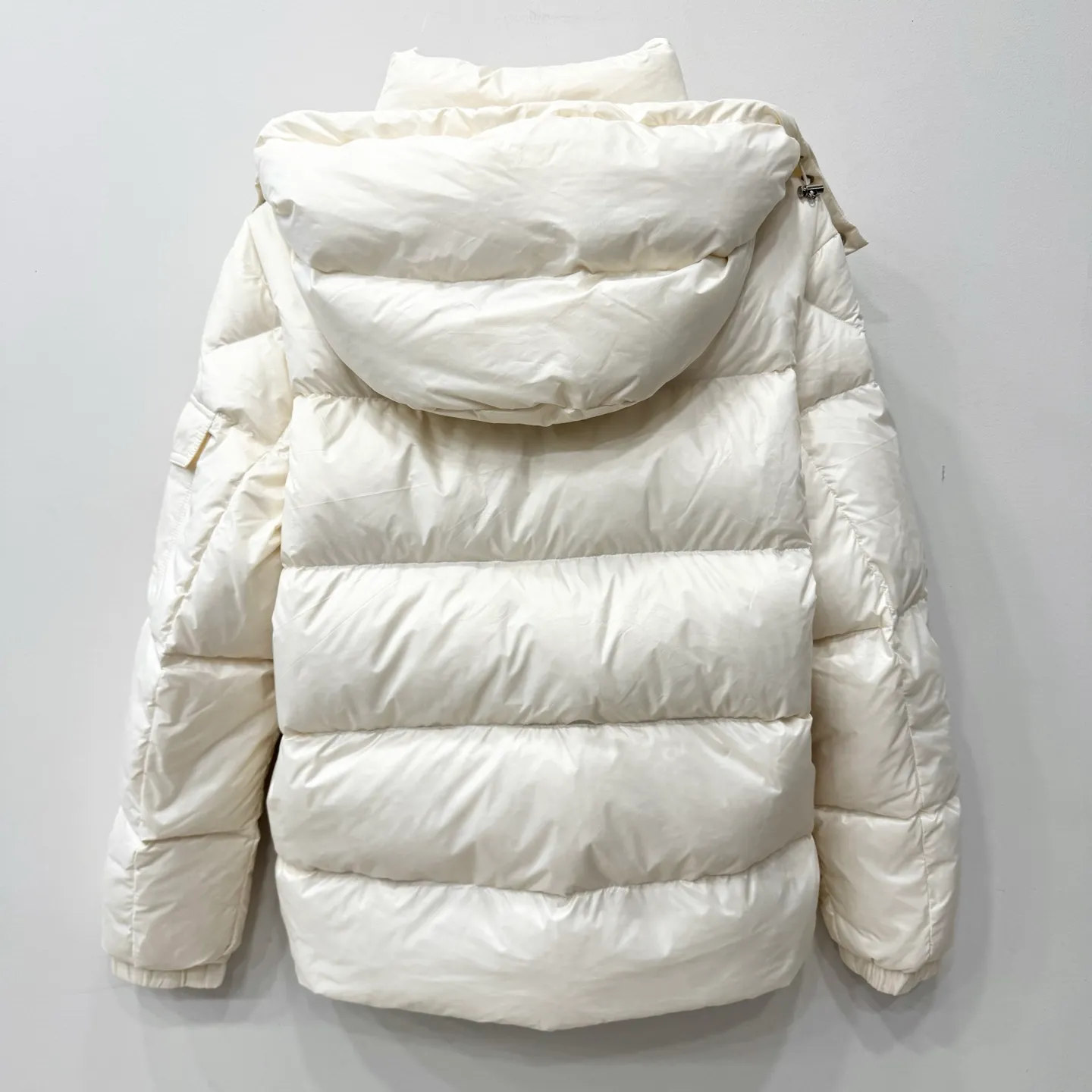 P1100 Brand: Moncler Filling: 90 white duck down Weight: 380-450 Color: White Black Gray Size: 12345 [Couyere Men's Hooded Short Down Jacket] The Couyere short down jacket is durable and practical, provides functional warmth and care, and will accompany you to meet challenges.  The Couyere is a durable down jacket made from a fine fabric that's durable and functional, with velvet resistance and functionality. The short design creates a sculpted silhouette, and padded pockets add a modern feel. The sleeves are embellished with signature patch pockets, a nod to the classic Moncler Maya down jacket.  • Made of fine ripstop fabric • Fine fabric lining • Down filling • Detachable and adjustable hood • Zip closure • Zippered pockets • Press-studs on sleeve pockets • Elastic cuffs • Drawstring hem Fabric: 100% nylon; Lining: 100% nylon; Filling: Goose down Down content: 90%; except upholstery; Maximum wash temperature 30°C - Mild wash; Do not bleach; Do not tumble dry; Ironing maximum temperature 110°C - without steam; Hydrocarbon dry cleaning - gentle wash; Professional wet cleaning - gentle wash; Lay flat to dry in shade; Wash separately; Remove removable accessories before washing; Recommend washing and ironing inside out