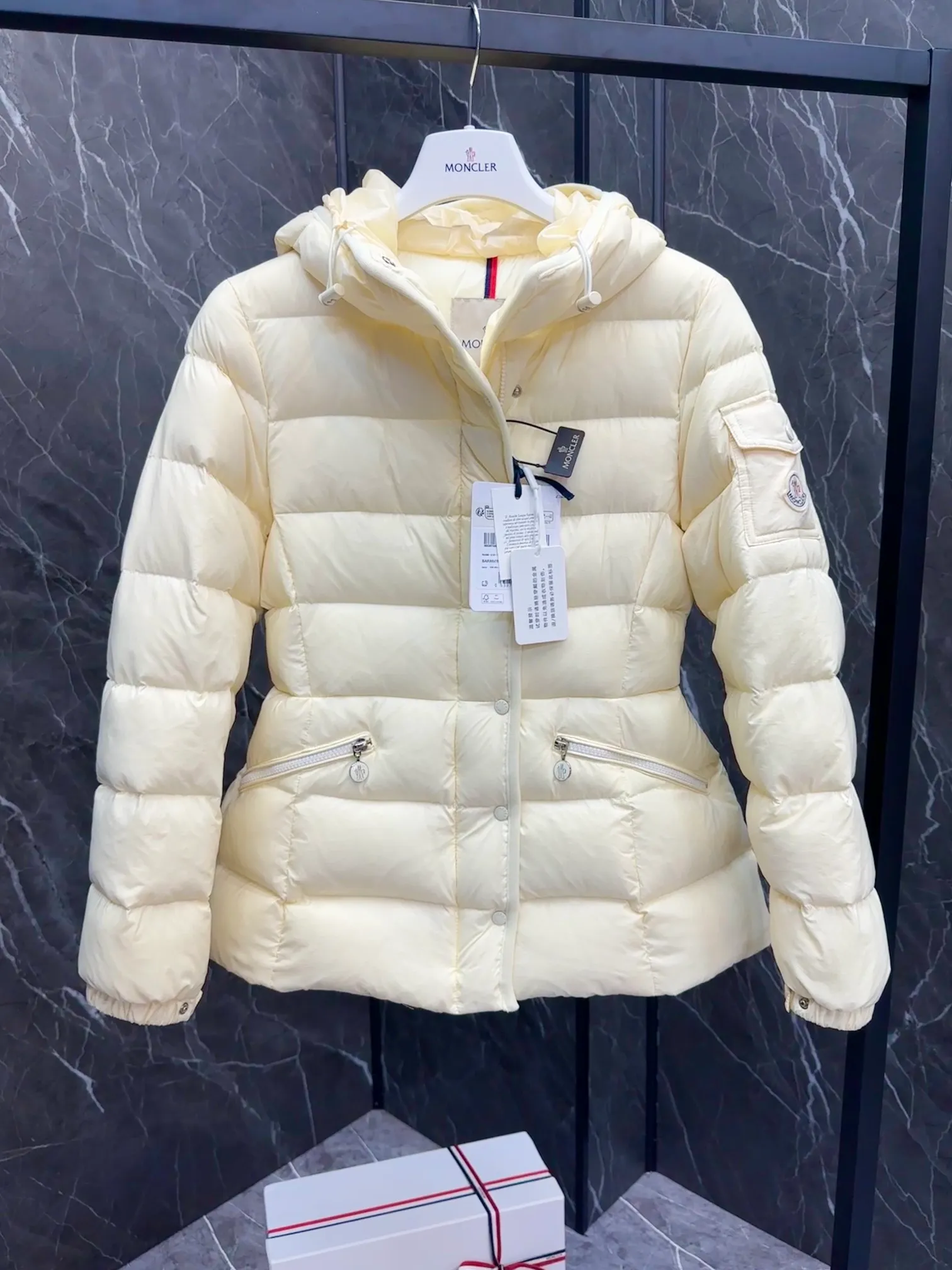 P780 Hot Sale ⬆️Moncler Barante Women’s Short Down Jacket The Barante short down jacket combines femininity with practical functions, reinterpreting the aesthetic style of the 1970s for modern women. The Barante down jacket is made from lustrous nylon and is inspired by the 1970s. It adopts a waist design and presents an A-line silhouette, highlighting a feminine style. An adjustable hood and signature logo patch add finishing touches. Details •Made of nylon laqué fabric •Nylon laqué lining •Down filling •Adjustable hood •Zip and snap closure •Suit pocket •Adjustable cuffs Size : 0-3. Snow White/Light Pink/Black.