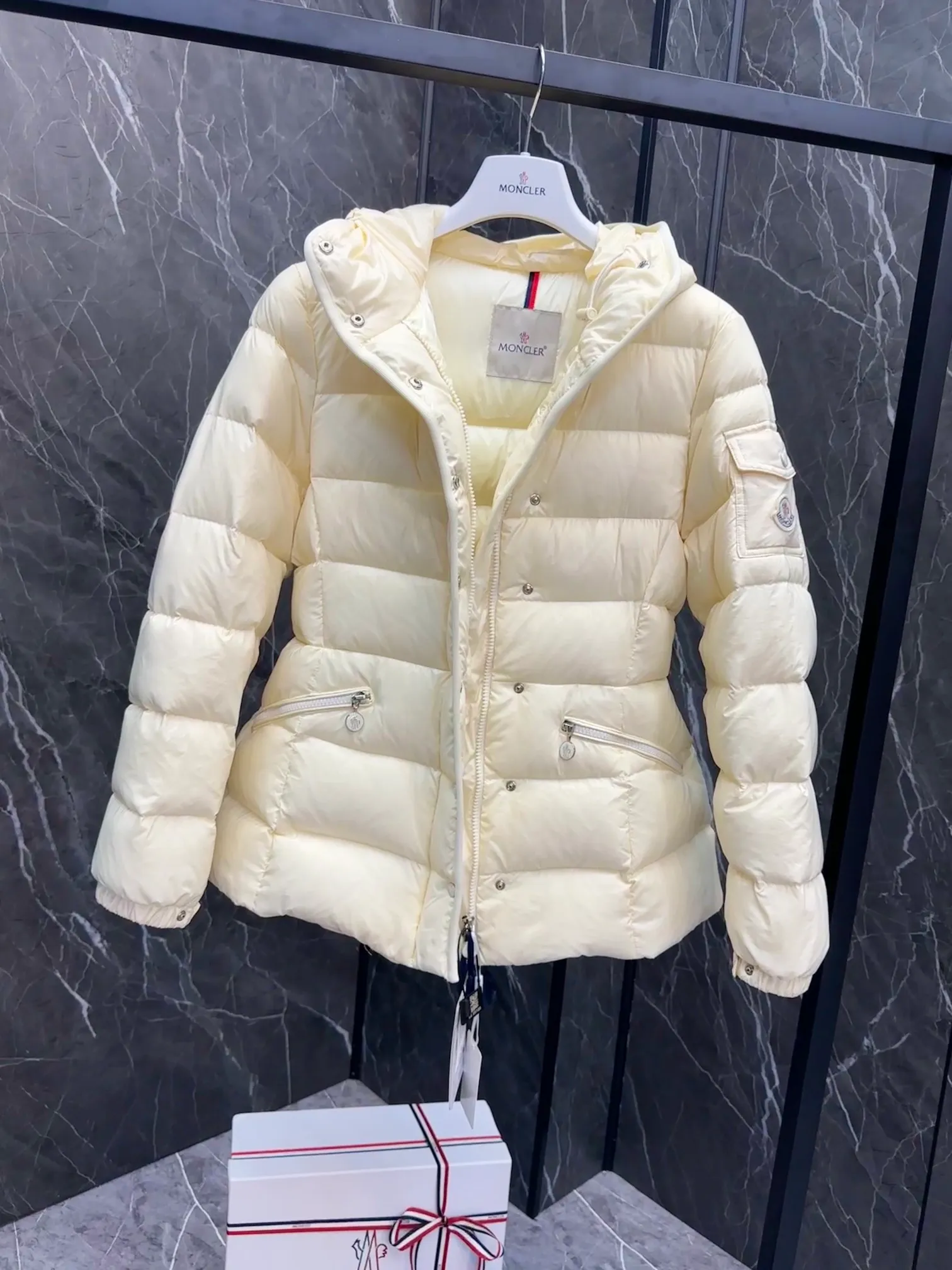 P780 Hot Sale ⬆️Moncler Barante Women’s Short Down Jacket The Barante short down jacket combines femininity with practical functions, reinterpreting the aesthetic style of the 1970s for modern women. The Barante down jacket is made from lustrous nylon and is inspired by the 1970s. It adopts a waist design and presents an A-line silhouette, highlighting a feminine style. An adjustable hood and signature logo patch add finishing touches. Details •Made of nylon laqué fabric •Nylon laqué lining •Down filling •Adjustable hood •Zip and snap closure •Suit pocket •Adjustable cuffs Size : 0-3. Snow White/Light Pink/Black.