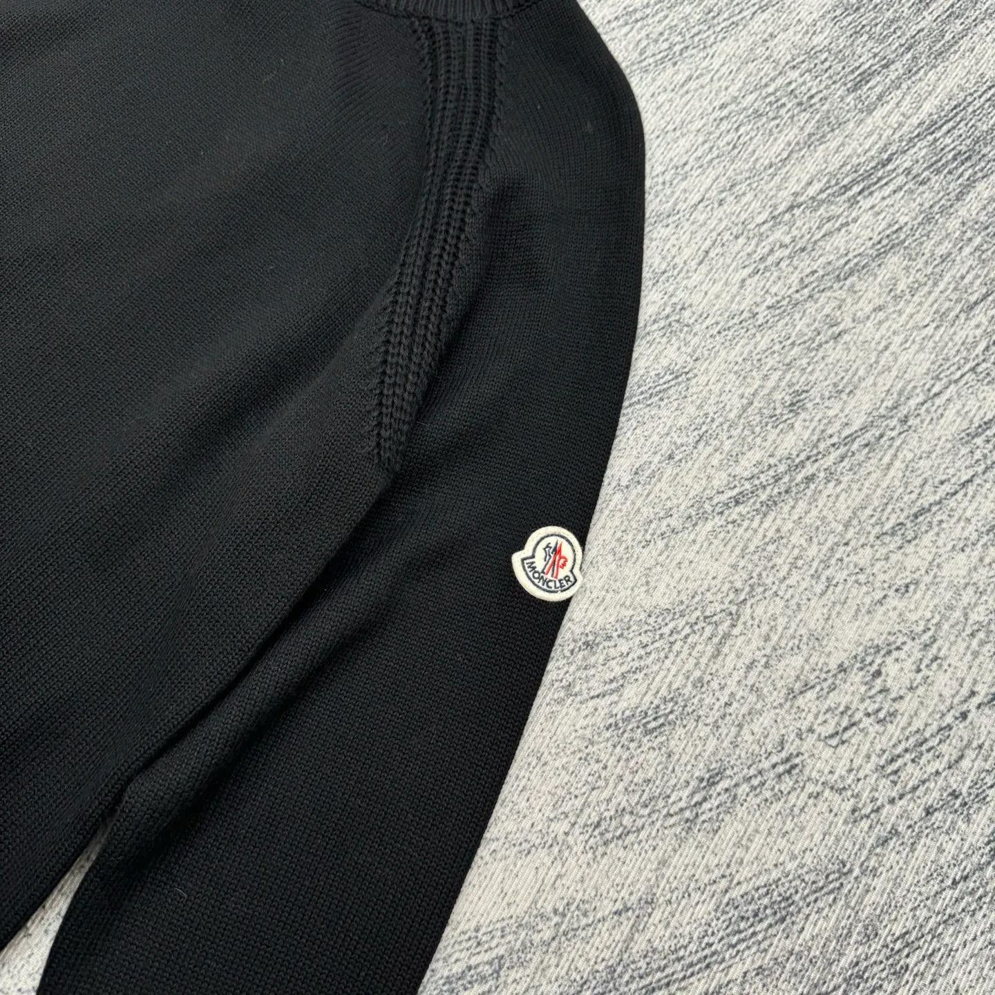 P430 Moncler Mouth Logo High Neck Knitted Long Sleeve Sweater Size: S/M/L/XL The sweater adopts high collar knitting technology, and the neck texture is tight and elastic, which is both warm and stylish. In terms of detailed craftsmanship, hollow knitting splicing technology is used on the shoulders, with fine texture and distinct layers, which enhances the design sense of the body; the contrasting rib technology on the cuffs and hem forms a soft contrast with the main color, improving the overall sophistication; the brand logo on the left arm uses three-dimensional embroidery technology, with precise stitching, highlighting the brand recognition. Made of high-quality knitted fabrics and made with fine weaving technology, it is skin-friendly, comfortable and has a crisp silhouette. From the warm design of the collar to the details of the embroidery, every craftsmanship reflects the brand's dual pursuit of quality and fashion. It is an autumn and winter item that combines practicality and design. Purchase the original version for development, order the color and dye it, and feel free to compare it with any version on the market!