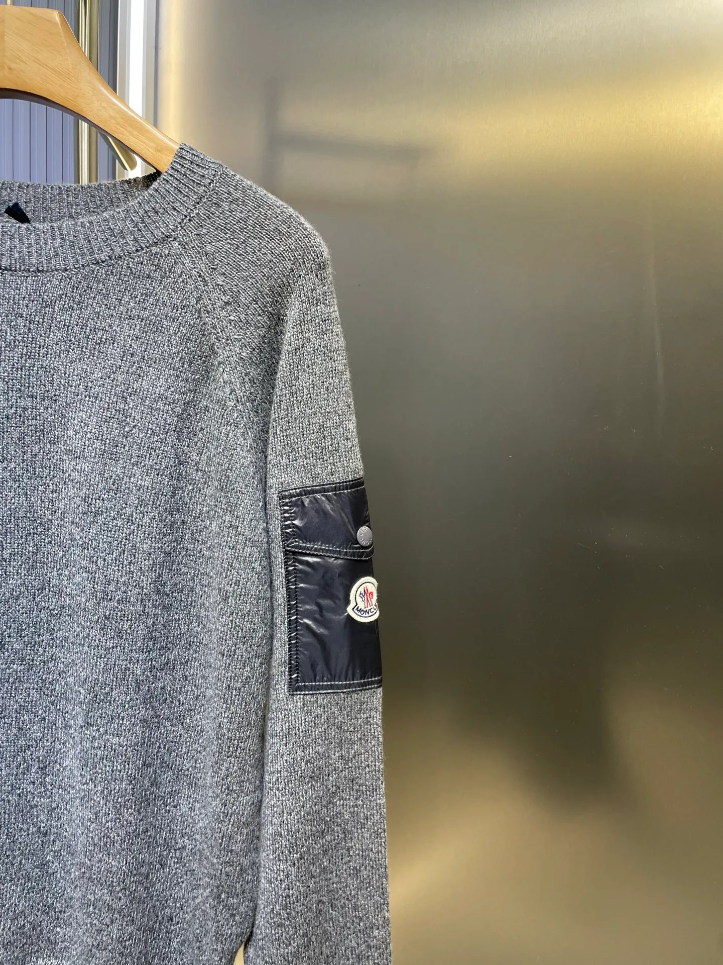 P390 Moncler Hooded Sleeve Pocket Crew Neck Sweater was originally purchased and developed for RMB 6,950. The fabric is made of 30% wool double-ply blended wool. The main body of wool ensures the warmth and comfort of the clothing. The addition of a small amount of nylon and spandex significantly improves the elasticity and wear resistance. The ribbed decorative parts are made of 100% wool, which further enhances the overall texture. Through a high needle count and fine gauge loom, combined with the orderly direction of the internal yarn, the floating yarn is cleverly woven and stored, with almost no unnecessary thread mess. The nylon pockets on the sleeves are embellished with the brand logo, which is low-key and luxurious.  Size:S-M-L-XL
