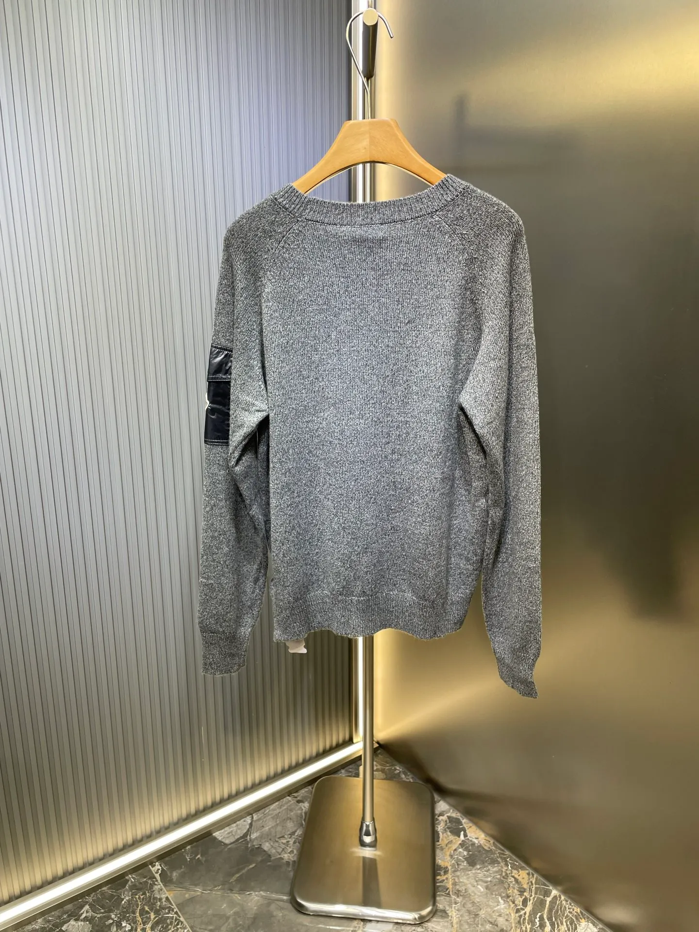 P390 Moncler Hooded Sleeve Pocket Crew Neck Sweater was originally purchased and developed for RMB 6,950. The fabric is made of 30% wool double-ply blended wool. The main body of wool ensures the warmth and comfort of the clothing. The addition of a small amount of nylon and spandex significantly improves the elasticity and wear resistance. The ribbed decorative parts are made of 100% wool, which further enhances the overall texture. Through a high needle count and fine gauge loom, combined with the orderly direction of the internal yarn, the floating yarn is cleverly woven and stored, with almost no unnecessary thread mess. The nylon pockets on the sleeves are embellished with the brand logo, which is low-key and luxurious.  Size:S-M-L-XL