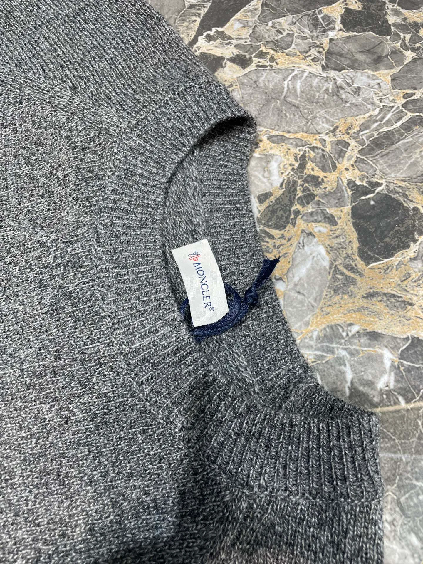 P390 Moncler Hooded Sleeve Pocket Crew Neck Sweater was originally purchased and developed for RMB 6,950. The fabric is made of 30% wool double-ply blended wool. The main body of wool ensures the warmth and comfort of the clothing. The addition of a small amount of nylon and spandex significantly improves the elasticity and wear resistance. The ribbed decorative parts are made of 100% wool, which further enhances the overall texture. Through a high needle count and fine gauge loom, combined with the orderly direction of the internal yarn, the floating yarn is cleverly woven and stored, with almost no unnecessary thread mess. The nylon pockets on the sleeves are embellished with the brand logo, which is low-key and luxurious.  Size:S-M-L-XL