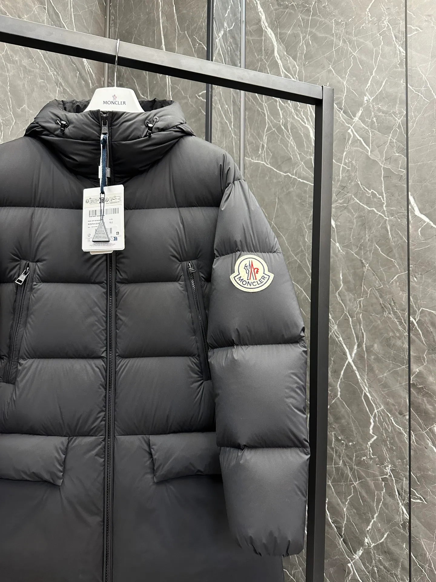 P880 ⬆️Moncler Bosona mid-length large felt badge down jacket. A popular style. Good-looking for both men and women. ❗️❗️❗️ This Bosona men's long down jacket combines Moncler's classic aesthetics, excellent performance and protective features.  The Bosona long down jacket is made of longue saison fabric and is designed with practical details to provide both warmth and protection. As a Moncler classic, this down jacket features a detachable hood and a front zipper placket that covers the windshield, significantly improving its protective performance. Details •Made from longue saison fabric •Longue saison lining •Filled with down •Removable hood •Zip and snap closure •Zip pockets •Patch pockets on sleeves •Adjustable cuffs •Drawstring hem Size: 1-5 Couple D74108056980