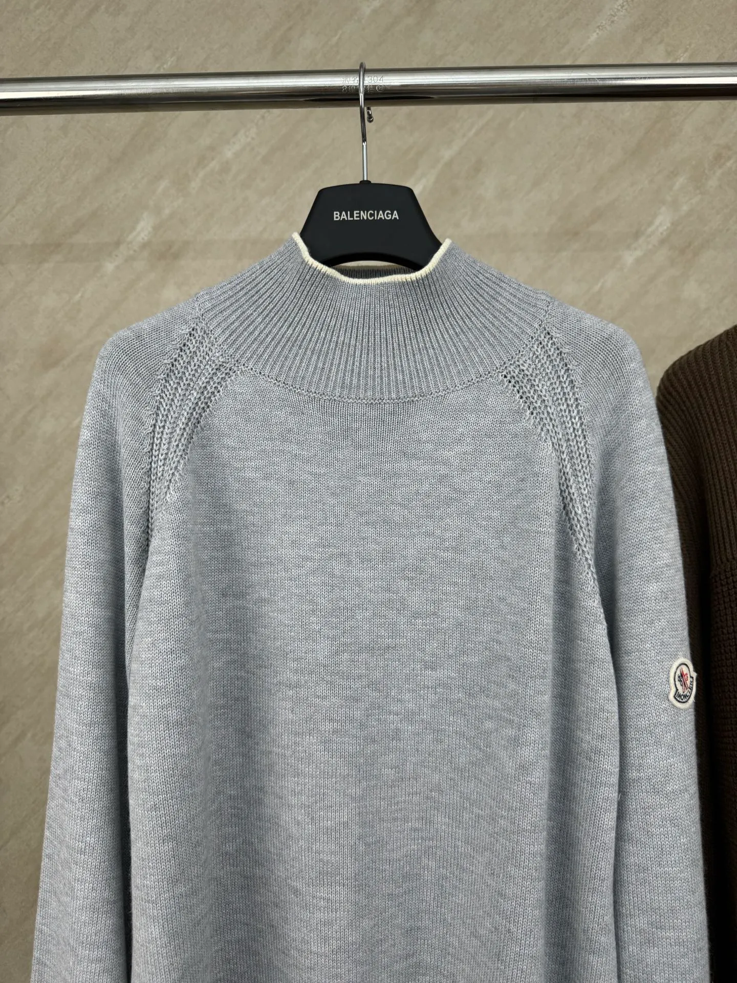 P430 Moncler Mouth Logo High Neck Knitted Long Sleeve Sweater Size: S/M/L/XL The sweater adopts high collar knitting technology, and the neck texture is tight and elastic, which is both warm and stylish. In terms of detailed craftsmanship, hollow knitting splicing technology is used on the shoulders, with fine texture and distinct layers, which enhances the design sense of the body; the contrasting rib technology on the cuffs and hem forms a soft contrast with the main color, improving the overall sophistication; the brand logo on the left arm uses three-dimensional embroidery technology, with precise stitching, highlighting the brand recognition. Made of high-quality knitted fabrics and made with fine weaving technology, it is skin-friendly, comfortable and has a crisp silhouette. From the warm design of the collar to the details of the embroidery, every craftsmanship reflects the brand's dual pursuit of quality and fashion. It is an autumn and winter item that combines practicality and design. Purchase the original version for development, order the color and dye it, and feel free to compare it with any version on the market!