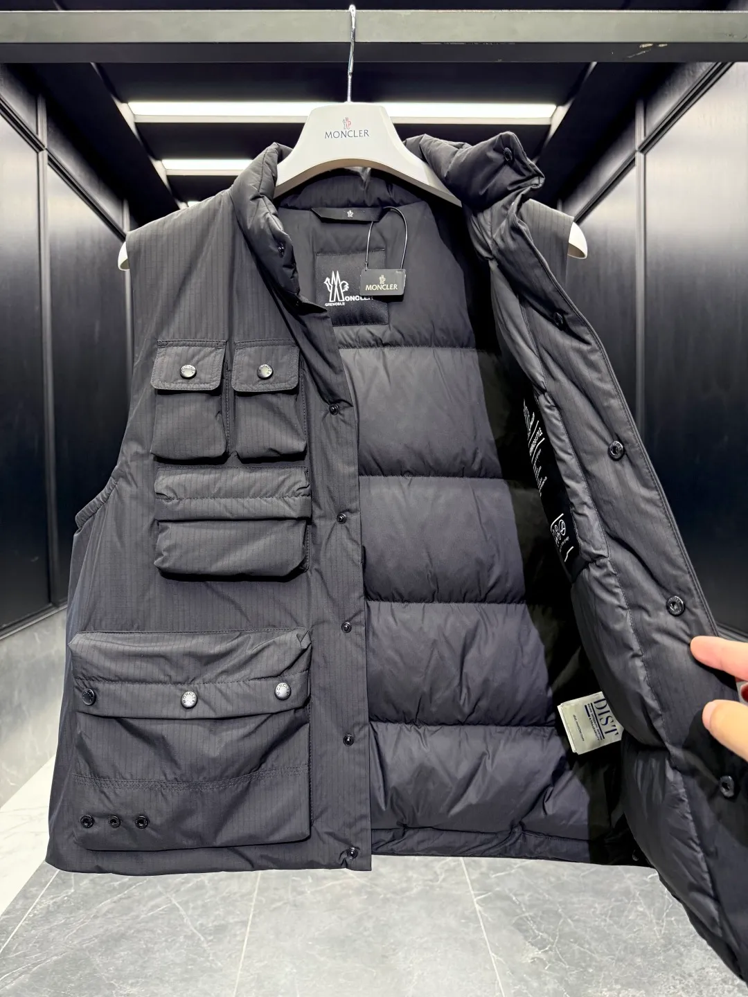 P820 ​​Premium Down ⬆️Moncler Grenoble Tongass Down Outdoor Vest. High-end Black Label Series. Original replacement fabric. Premium duck neck down filling. The Tongass Down Vest provides protection without being heavy and is specially designed for outdoor activities in mild weather.  The Tongass down vest is the result of research into lightweight performance outerwear. Functional fabric is tight and durable without adding extra weight. Features a large utility pocket and carabiner clip to reduce the amount of luggage you carry. Details •Designed for outdoor activities •Made from tight fabric •Polyester lining •Down filling •Snap button closure •Utility pockets with snap, zip and Velcro closure •Drawstring hem •Front carabiner •Reflective details Size: 1-5 Light Brown/Black D00780