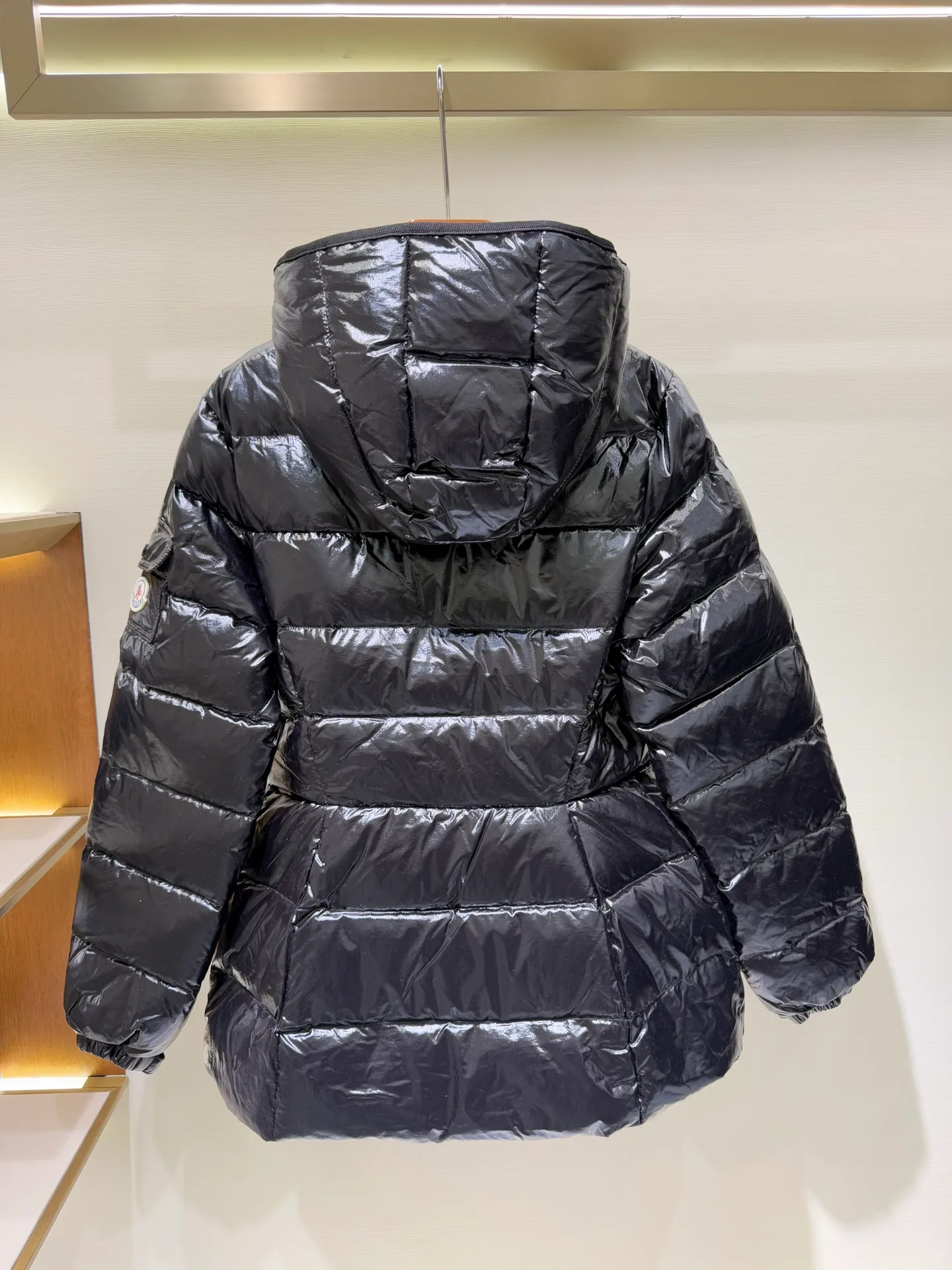 P1140 Moncler Barante series short waisted down jacket. The Barante down jacket is made of glossy nylon fabric and is inspired by the 1970s. The short version features a nipped-in waist and an A-line silhouette, highlighting a feminine style. An adjustable hood and signature logo patch add finishing touches.  Fabric: Made of nylon laque fabric, Nylon laque lining, filled with down (90 white goose down) Craftsmanship: Adjustable hood, zipper and snap button closure, zipper pocket Adjustable cuffs (supports NFC function) Color: black pink off-white Size: 0 1 2 3 4446080
