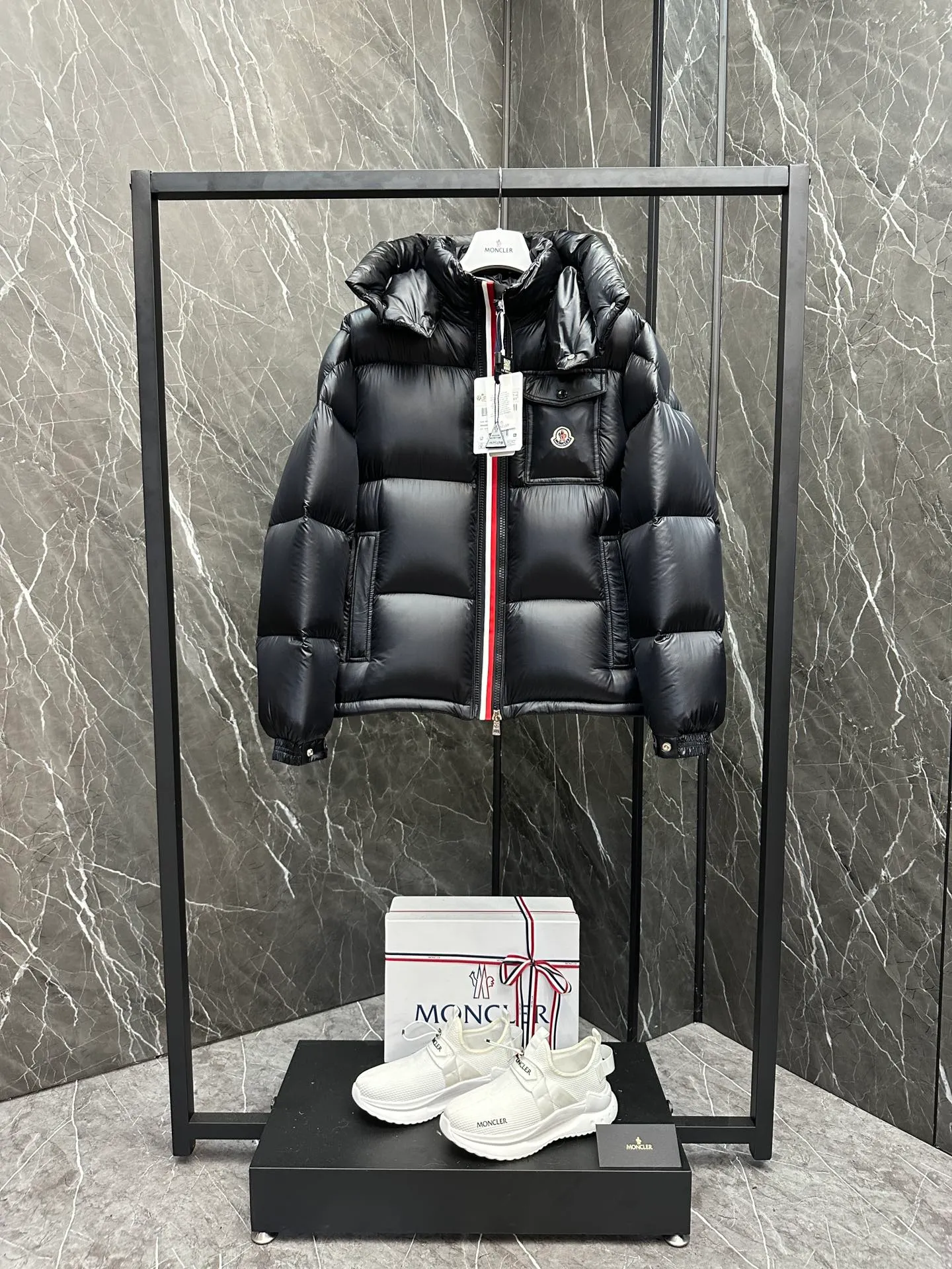 P740 ⬆️Moncler Montbeliard Short Men's Down Jacket Jacket Montbeliard Men's Short Down Jacket has warmth and protection functions, highlighting the fashionable Moncler aesthetic, and is a popular product. The Montbeliard down jacket is made from shiny patented nylon and features recognizable rectangular quilting. Featuring a hooded design and signature patch pocket at chest. Details •Made from nylon laqué fabric •Nylon laqué lining •Filled with down •Removable and adjustable hood with drawstring closure •Internal flap with webbing •Black pocket detail at lower end •Zipper closure •Snap-button closure at collar •Zipper pockets •Push-button closure at patch pockets •Adjustable cuffs •Adjustable elastic drawstring hem Size: 1-5 Couple's Black D9875067650