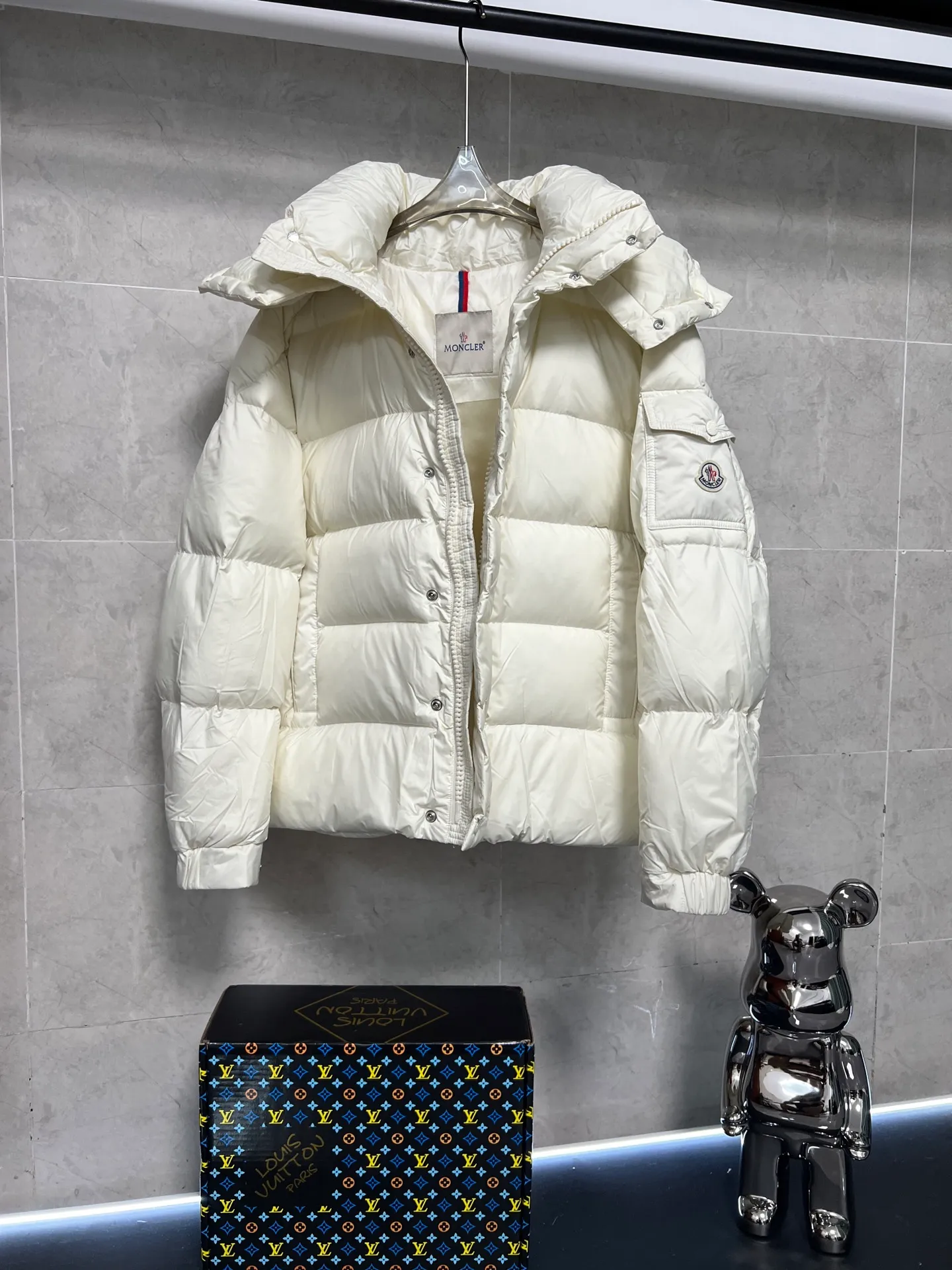 P800 Moncler matte Maya short down jacket. This short parka down jacket is made of longueSaion fabric. The garment is full of functional details to ensure warmth and care. Features removable hood, zip pockets, adjustable cuffs, and snap-zip flap fly. Logo embellished sleeves. It adds a unique touch to the overall shape and significantly improves the protective performance. Color: Black White Pink Pearl White Size: 12345
