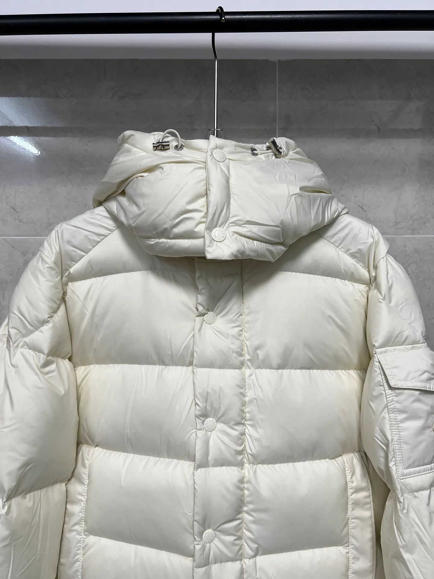 P800 Moncler matte Maya short down jacket. This short parka down jacket is made of longueSaion fabric. The garment is full of functional details to ensure warmth and care. Features removable hood, zip pockets, adjustable cuffs, and snap-zip flap fly. Logo embellished sleeves. It adds a unique touch to the overall shape and significantly improves the protective performance. Color: Black White Pink Pearl White Size: 12345