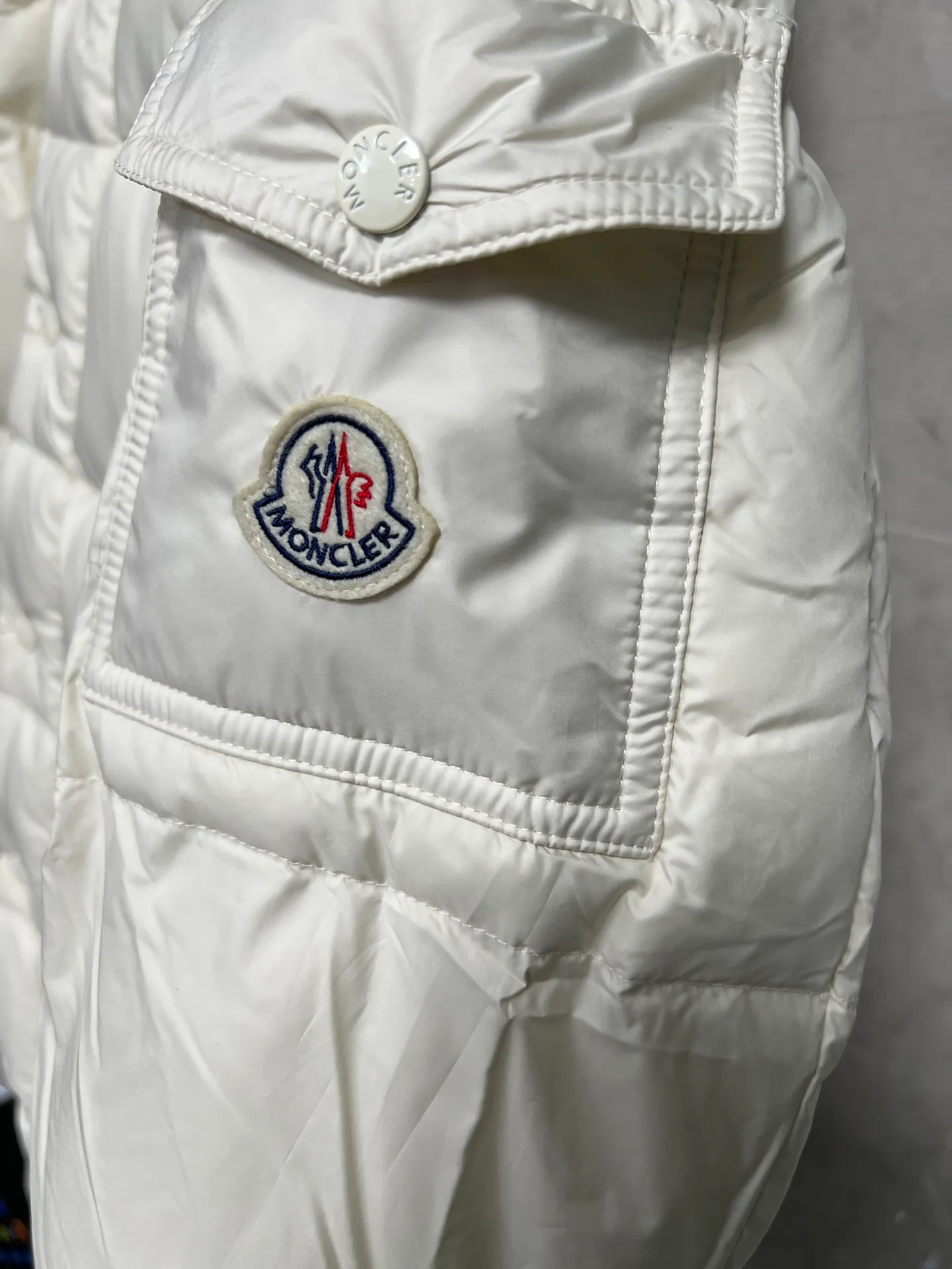 P800 Moncler matte Maya short down jacket. This short parka down jacket is made of longueSaion fabric. The garment is full of functional details to ensure warmth and care. Features removable hood, zip pockets, adjustable cuffs, and snap-zip flap fly. Logo embellished sleeves. It adds a unique touch to the overall shape and significantly improves the protective performance. Color: Black White Pink Pearl White Size: 12345