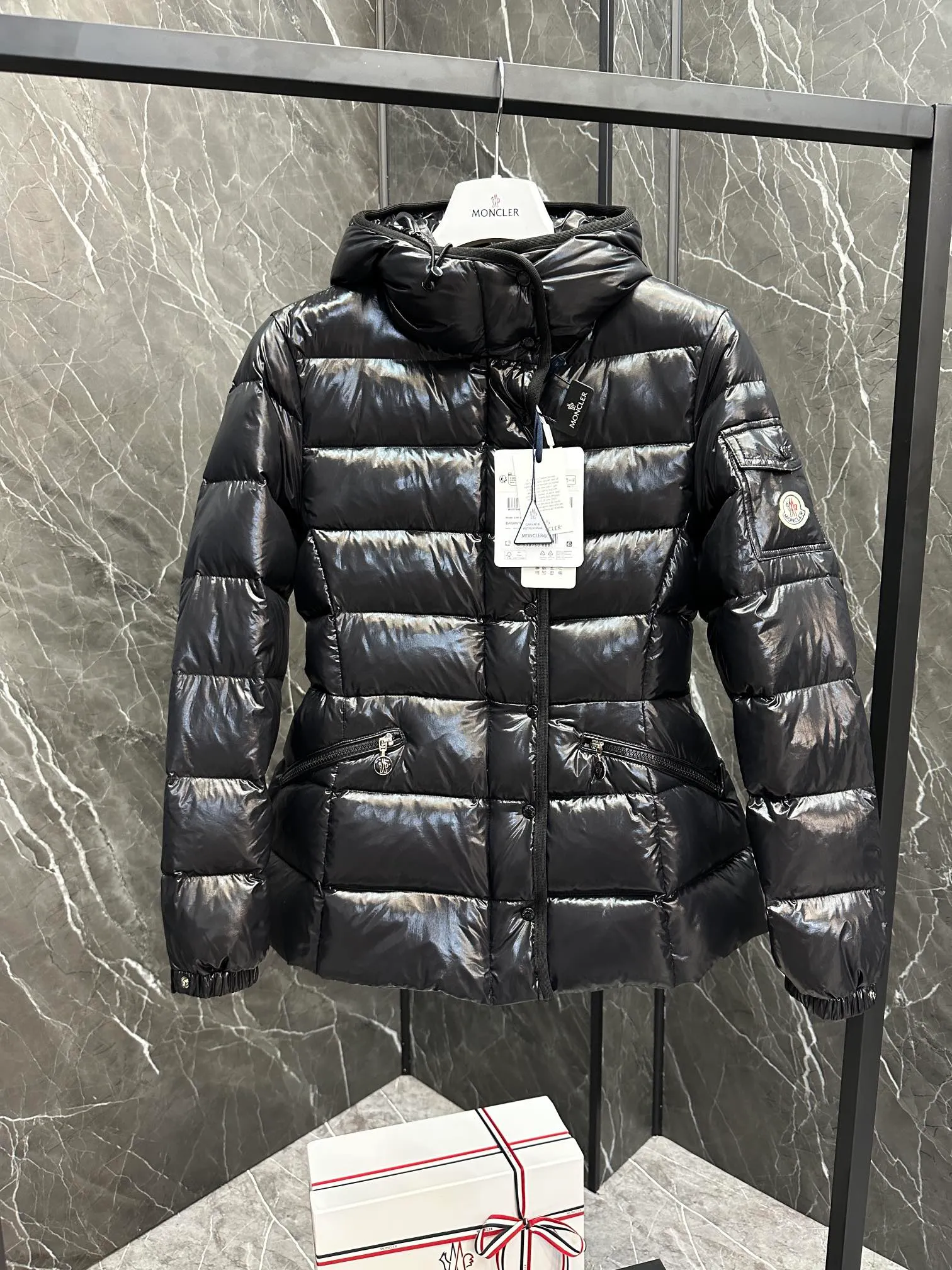 P780 Hot Sale ⬆️Moncler Barante Women’s Short Down Jacket The Barante short down jacket combines femininity with practical functions, reinterpreting the aesthetic style of the 1970s for modern women. The Barante down jacket is made from lustrous nylon and is inspired by the 1970s. It adopts a waist design and presents an A-line silhouette, highlighting a feminine style. An adjustable hood and signature logo patch add finishing touches. Details •Made of nylon laqué fabric •Nylon laqué lining •Down filling •Adjustable hood •Zip and snap closure •Suit pocket •Adjustable cuffs Size : 0-3. Snow White/Light Pink/Black.