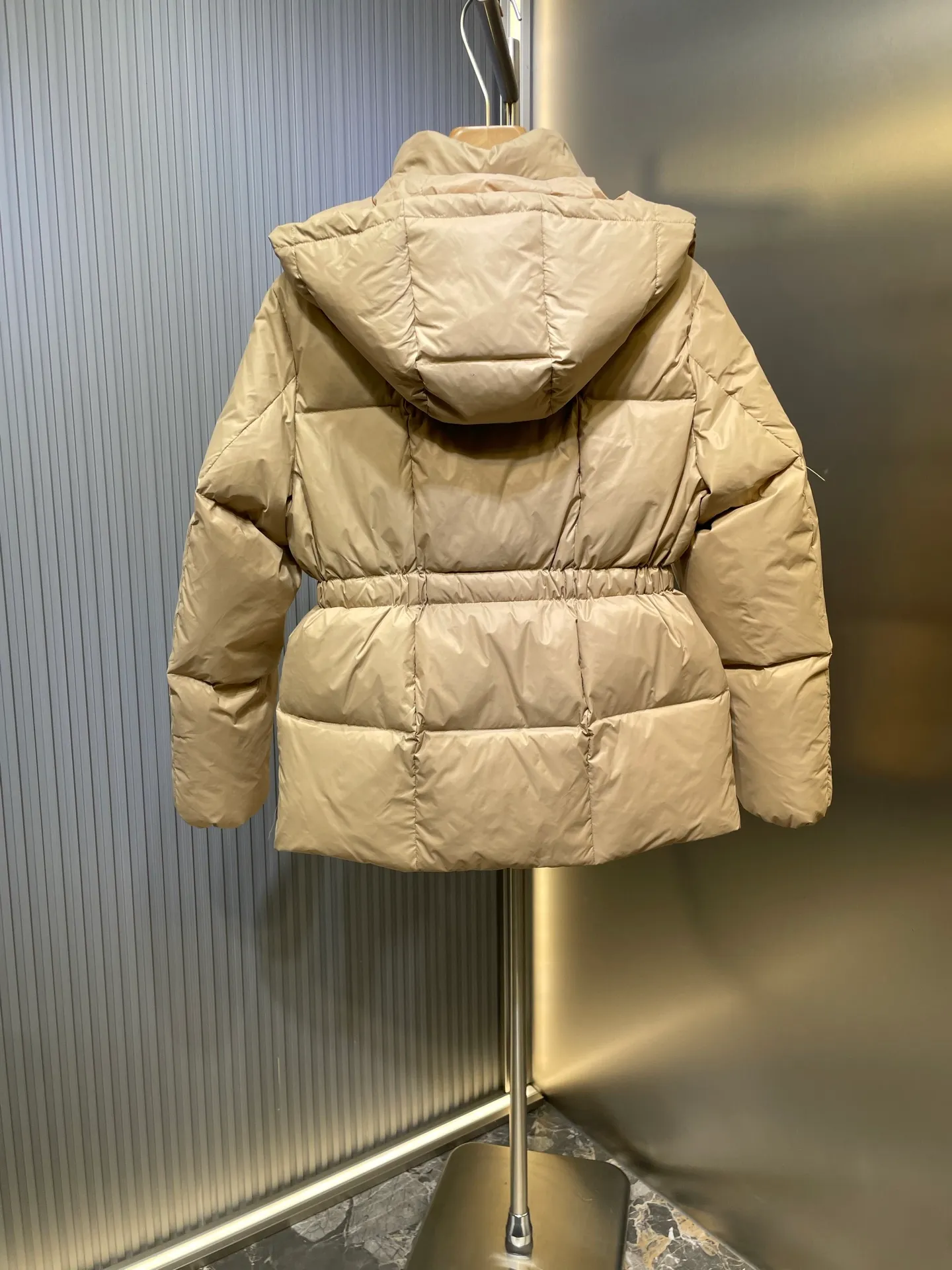 P910 MONCLER 25FW new autumn and winter product. Waisted black gold Agneux women's square quilted hooded short down jacket. The Agneux down jacket combines protective fabrics and exquisite textures. Short fit in functional nylon with a glossy satin finish. Paired with a nipped-in waist design, it outlines a feminine silhouette. Made of nylon Longue saison lining Filled with down Detachable and adjustable hood Zip and snap fastening Zippered pockets Elastic waist Black Apricot Sizes S M L