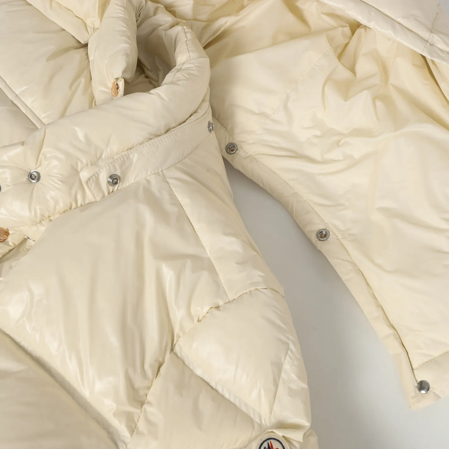 P920 Moncler/Meng Mouth Women's Square Quilted Hooded Short Down Jacket Fabric selection: Selected high-density super laqué nylon fabric, matched with lightweight down filling, and nylon lining design, which ensures excellent thermal performance while showing an avant-garde urban style.  Craftsmanship and details: The short silhouette is paired with innovative super laqué nylon fabric, which presents a unique glossy texture and perfectly blends functionality and fashion. Breakthrough asymmetrical tailoring, with double-button closure system. Three-dimensional geometric quilting technology, creating visual hierarchy through differentiated quilting sizes on the body and sleeves. Detachable and adjustable hood design to meet various dressing needs. Double closure system (zipper + snap button) ensures windproof and warm. Multifunctional storage space: zipper security pocket + snap-button chest pocket. Drawstring hem design, the tightness can be adjusted freely. 90 national standard high-quality white duck down: Selected high-loft down, weighing 210g, light and warm, with excellent temperature locking performance and good resilience.  Accessories: Customized armband Customized snap button Customized zipper puller Color: black/beige/green SIZE: 1/2/3/4