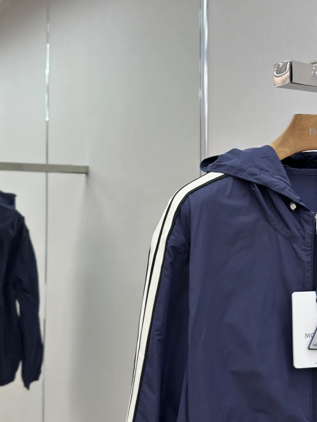 P560 MONCLER web-trimmed lightweight jacket Fabric selection: 100% polyester fiber is used to create a tough protective outer layer. It is known for its excellent tear resistance and wear resistance. It can quickly return to flatness during wearing and maintain the crisp and stylish appearance of the clothing for a long time. At the same time, it is not easy to deform after being washed for a long time.   Features: Two different colored decorative strips added to the center part of the sleeves. This design element can not only add visual highlights to clothing, making it more fashionable and unique. Craftsmanship: The webbing is precisely positioned along the cuffs to the seam of the collar and hat to ensure symmetry and overall smoothness. Before actual sewing, use very fine basting stitches for pre-fixing. This step is crucial to prevent the webbing from slipping, twisting, or wrinkling during sewing and ensuring that the final stitch is straight and perfect.  Accessories: Custom zipper puller, custom buttons with logo, custom hood drawstring elastic buckle SIZE: 1 2 3 4