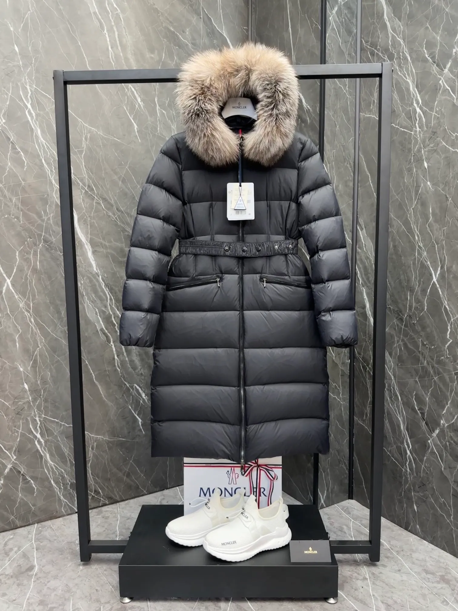 P1020 Moncler Boedic long down jacket for women. (Classic fox fur collar) adopts a whole fox fur collar imported from Finland. The Boedic long down jacket combines exquisite materials and attention to details. The timeless and elegant fashion design can provide you with a warm and caring wearing experience.  Boedic's long down jacket features a waist-cinching belt to accentuate its feminine silhouette for a stylish winter look. The cozy hood has rich fleece trim and is easily removable to suit your mood and weather conditions. Details • Made of lounge saison fabric • Longue saison lining • Filled with down • Hood with removable fox fur collar trim • Two-way zipper closure • Elastic waistband with snap button closure • Zippered pockets with grosgrain detail • Elastic cuffs Size : 1-4 .