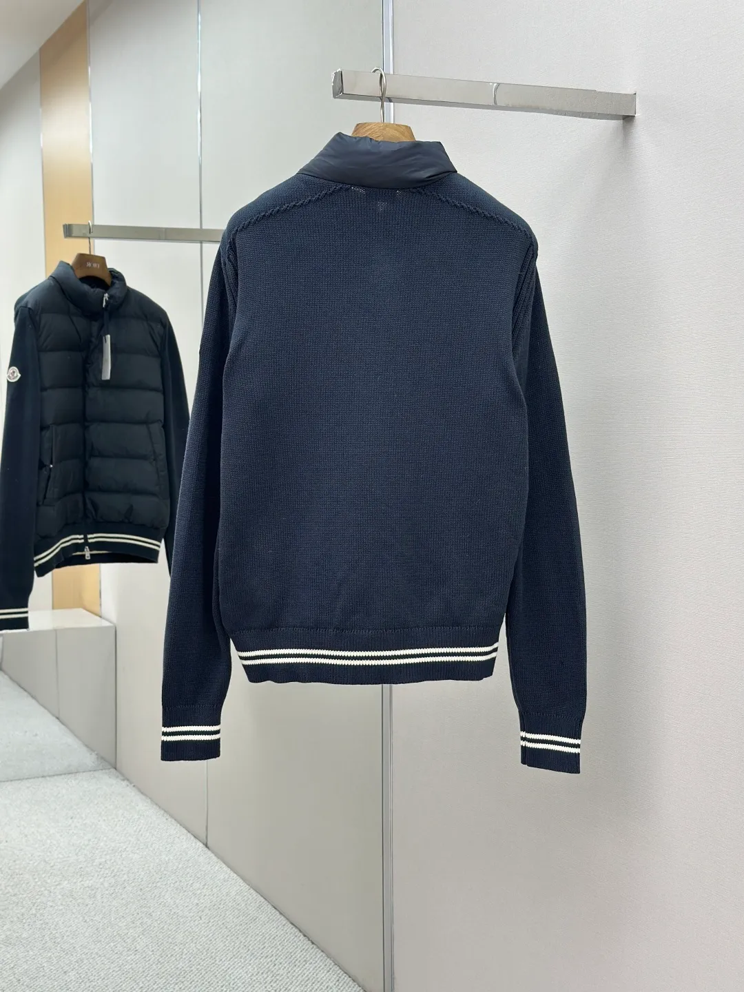 P830 Moncler Wool Splicing Fabric Selection: The front body fabric is made of 100% polyester fiber high-density weaving, with a thickness of 0.08mm to avoid increasing the overall weight and being smooth. The high-density weaving structure forms a wind resistance layer to protect the thermal efficiency of the thermal insulation layer from loss. At the same time, it can withstand the expansion pressure of down and prevent deformation and damage after long-term use.  The splicing design of the hood not only retains the warmth retention performance, but also incorporates the fashion elements, making the whole thing both practical and fashionable.  High-quality material: It is famous for its high-quality white duck down filling, with a filling capacity of 110g, and excellent warmth retention effect. At the same time, some are made of natural fiber materials such as wool and cashmere, which are soft, comfortable and skin-friendly.  The splicing process is exquisite to ensure comfortable wearing and not easy to get off-line or velvet.  High collar design: not only provides excellent thermal insulation effect, but also adds a unique sense of fashion, allowing the wearer to maintain style in the cold season.  Stripe decoration: The stripes on the cuffs and hem are like bright brushstrokes, embellished on the navy blue, injecting vitality and movement into the overall shape, making it more eye-catching.  Accessories: Customized zipper puller Customized badge Size: 1 2 3 4