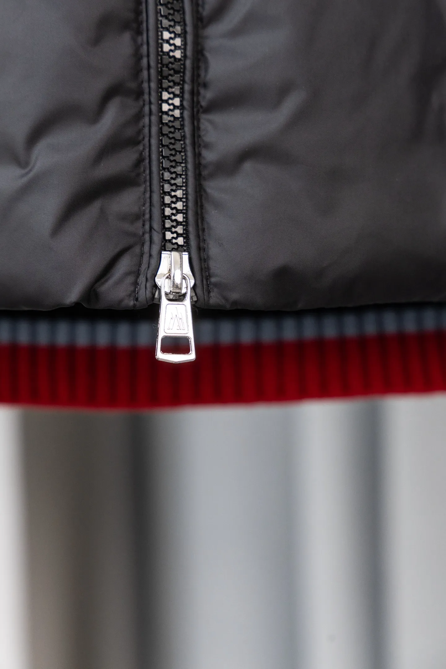 P560 Style number: M046 This is a knitted patchwork down jacket from Moncler. It combines the brand's high-end outdoor genes and fashion design. It is a luxurious item with both warmth and style in autumn and winter. Design highlights: Material splicing: Pure wool knitted sleeves are spliced ​​with a down front filled with 90 white duck down. The knitted part is soft and breathable, and the down part is fluffy and warm, achieving a dual fusion of style and function.  Detailed logo: The iconic Moncler badge pocket on the left arm is a classic embodiment of brand recognition; the stand-up collar design with a two-way zipper not only improves warmth, but also strengthens the neat styling.  Color embellishment: The contrasting red and blue stripes on the cuffs and hem inject vitality into the overall black tone, adding a retro college style charm. Craftsmanship and Quality: The down filling follows the European standard 90 down standard, with excellent fluffiness and down filling, with almost no stiff feeling. At the same time, it adopts the "line first and then separate down filling" process. The four-layer liner effectively prevents down from being drilled, and can maintain warmth even after long-term wear.  The knitted part is made of high-quality wool, which has a delicate touch and is not easily deformed. The splicing process with the down fabric is rigorous, showing a high-end texture level.  Style and Wearing This down jacket is based on the classic college style. The slim straight version can modify the body line and can be easily adapted to a variety of styles: it can be paired with jeans and casual shoes for a casual look on a daily basis. It can also be upgraded to an urban light luxury style by layering it with a turtleneck sweater inside and a suit outside. It is a key item in the winter wardrobe that is both practical and fashionable. Color: black, navy blue, sizes S-XL