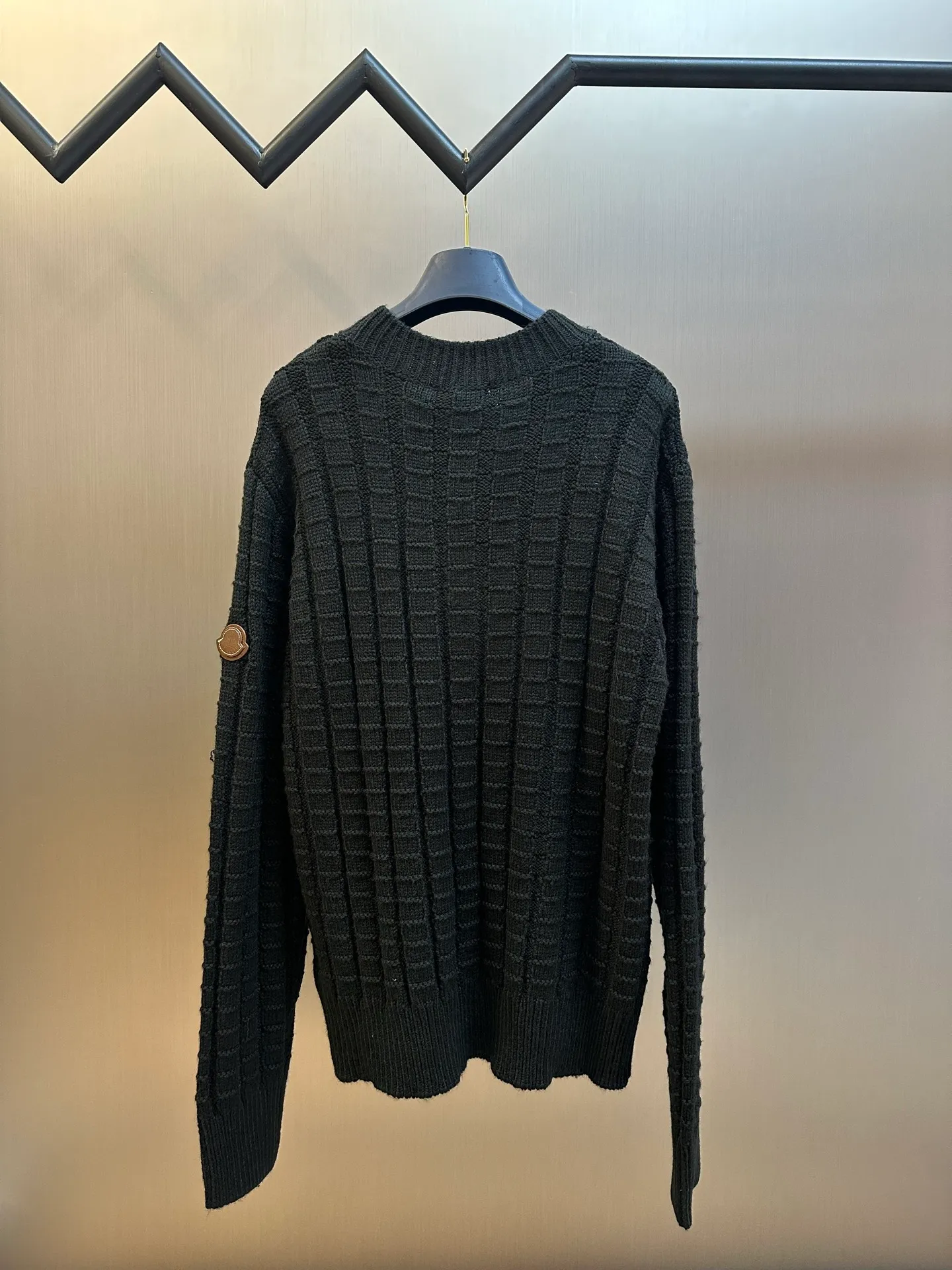 P430 Moncler embossed knitted logo sweater is made of custom-woven engraved wool texture, with three-dimensional texture as the brushstrokes. The entire embossed knitting reconstructs the dimension of knitted aesthetics. It produces a light and dark gradient texture halo as the human body moves. The iconic Moncler logo embroidered logo decorates the sleeves, making it highly recognizable.  The whole piece of embossed vertical grain knitting uses specific stitches and changes in fabric structure, and changes the arrangement of stitches and the density of the fabric, so that the vertical grains present a relief effect that is raised on the surface of the sweater, forming undulating changes in the vertical grains.  Curved thread structure, by changing the stitching method and the arrangement of yarns during the knitting process, makes the yarns present a curved distribution in the fabric.  size：s m l xl