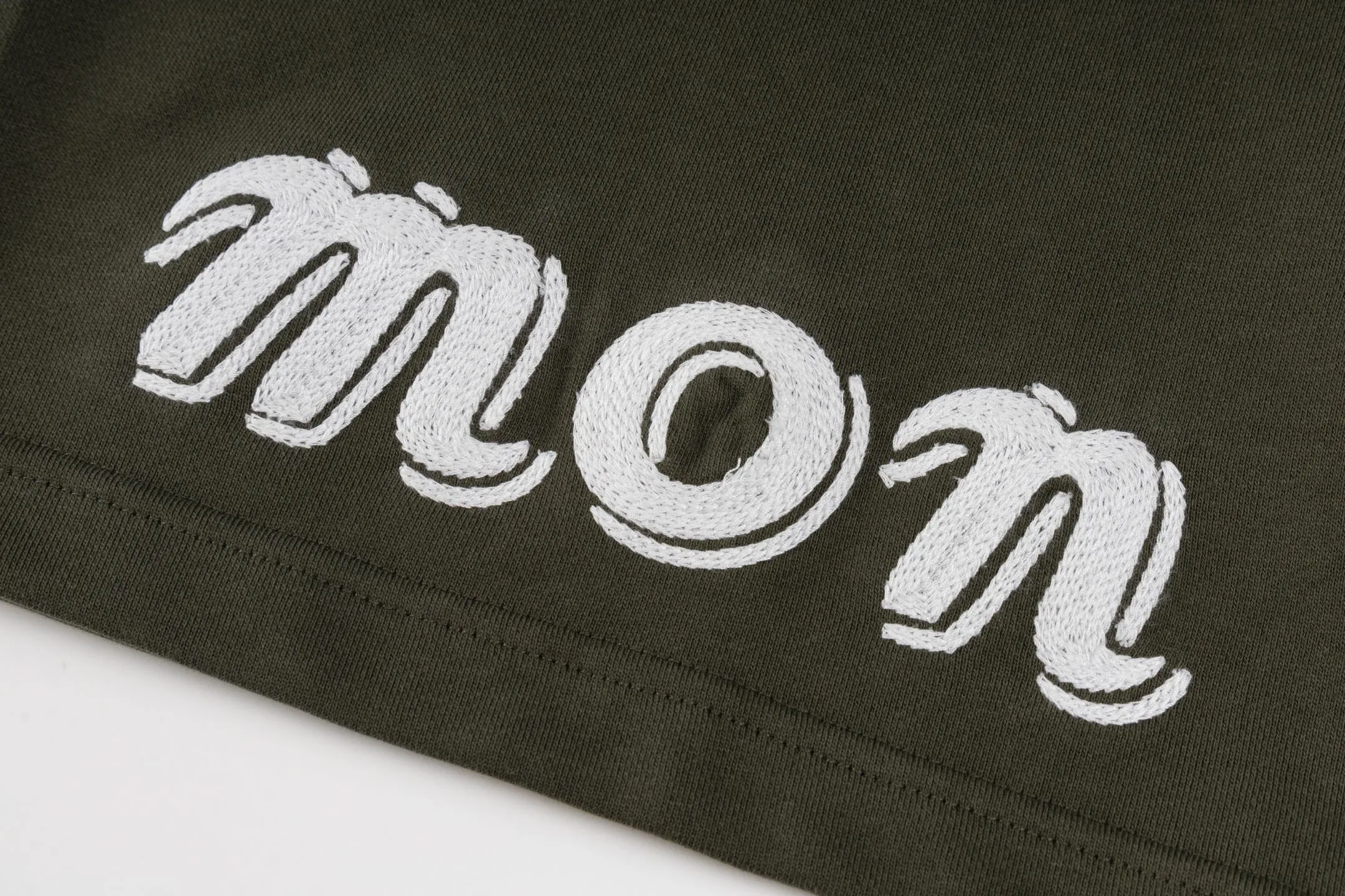 P300 Exclusive supply] Moncler Mouthless Three-Party Joint Shorts (Green) The fabric is made of single-sided fish-scale fabric woven with cotton as the base. The front is a smooth knitted surface, and the skin-contacting surface is formed into three-dimensional terry through the floating thread knitting technology of the knitting machine, which increases the fluffiness and has a delicate touch. The terry structure absorbs a large amount of water and evaporates quickly, so it is not easy to loosen and deform after repeated washing. The letters LOGO are embroidered on the back panel using 16,000 needles + 18,000 needles on the embroidery machine. The double-axis linear guide drives the embroidery frame, and the frame moving accuracy can reach 0.01mm/P, ensuring precise positioning of the embroidery pattern. By actively interfering with the shrinkage potential of cotton fibers, the fabric is able to transition from changeable to stable, improving dimensional stability while being less prone to deformation and wrinkles. Size:S-M-L-XL