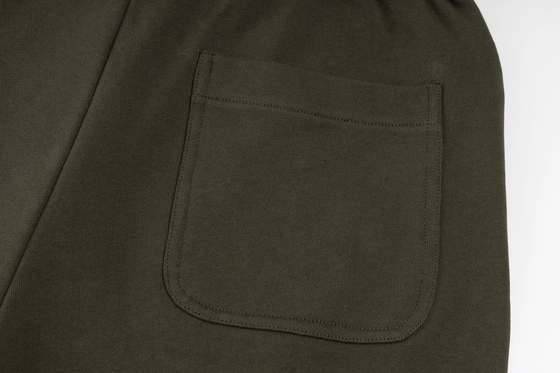 P300 Exclusive supply] Moncler Mouthless Three-Party Joint Shorts (Green) The fabric is made of single-sided fish-scale fabric woven with cotton as the base. The front is a smooth knitted surface, and the skin-contacting surface is formed into three-dimensional terry through the floating thread knitting technology of the knitting machine, which increases the fluffiness and has a delicate touch. The terry structure absorbs a large amount of water and evaporates quickly, so it is not easy to loosen and deform after repeated washing. The letters LOGO are embroidered on the back panel using 16,000 needles + 18,000 needles on the embroidery machine. The double-axis linear guide drives the embroidery frame, and the frame moving accuracy can reach 0.01mm/P, ensuring precise positioning of the embroidery pattern. By actively interfering with the shrinkage potential of cotton fibers, the fabric is able to transition from changeable to stable, improving dimensional stability while being less prone to deformation and wrinkles. Size:S-M-L-XL