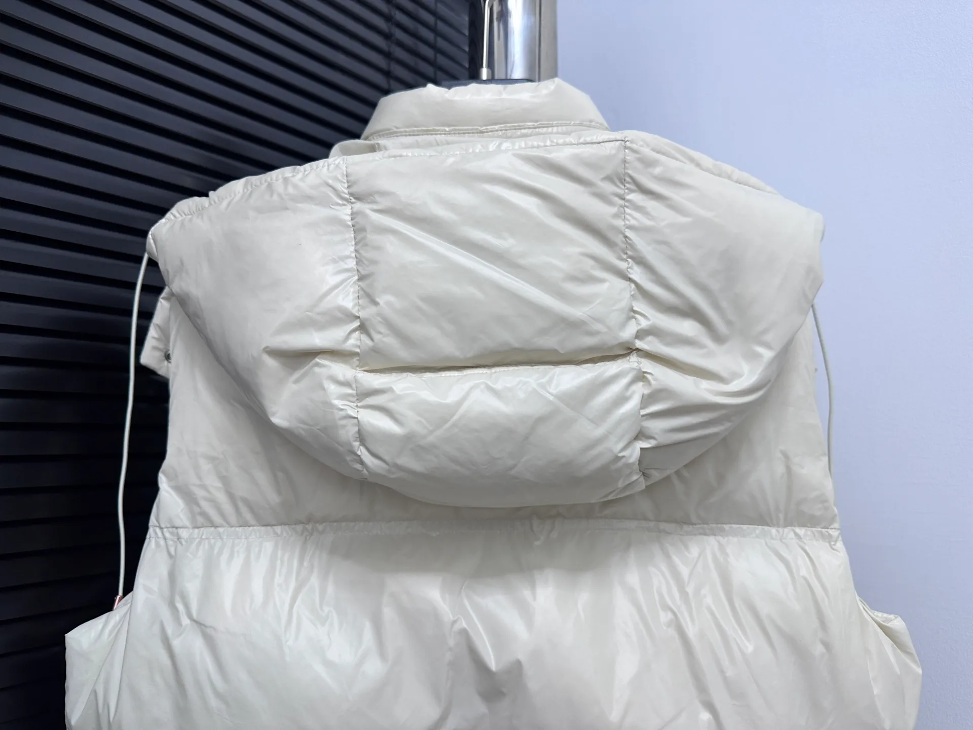 P740 [Moncler] Moncler's new autumn and winter product Pario women's hooded down vest. The Pario down vest cleverly uses shape and texture to show modern style. Made from functional super laque nylon fabric with a glossy finish. This hooded insulated piece features a double-snap closure for an asymmetrical shape. Trimmed with quilting in different sizes for a geometric feel. Size: 1-4 Color: Black Cream Mint Green