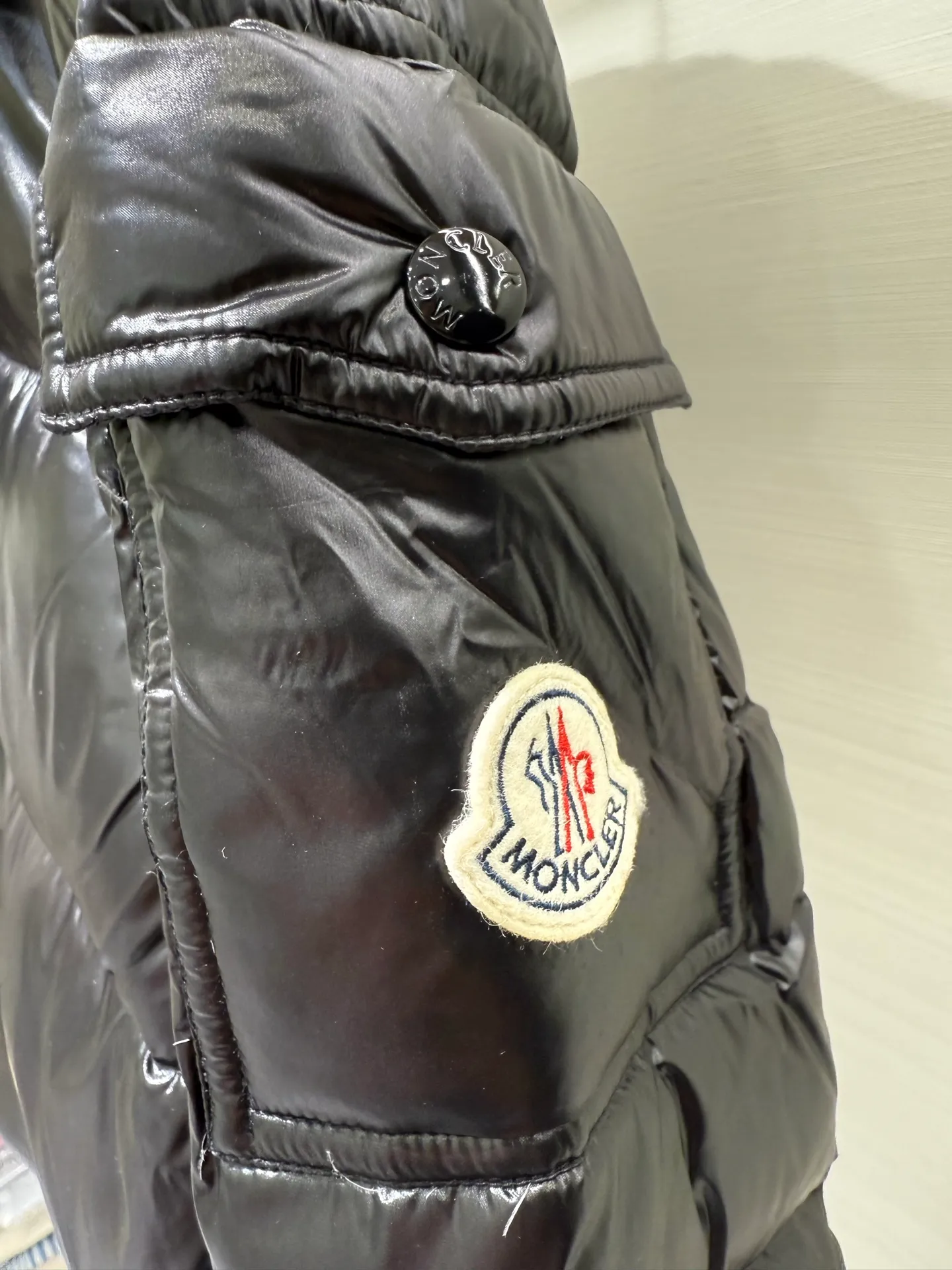 P1180 Moncler Maya Men's Men's Short Down Jacket The Moncler Maya men's down jacket is made of shiny patented nylon with signature rectangular quilting, which is a model of Moncler style. A classic cropped design that transcends seasons and styles, it features a statement silhouette, removable hood and adjustable hem. The sleeves are embellished with classic patch pockets, showcasing the brand's signature style.  Fabric: 100% nylon, 90% white goose down Craftsmanship: Made of lacquered nylon, lacquered nylon lining filled with down, rectangular quilting, detachable hood with snaps that can be adjusted by drawstring, two-way zip fly, external and internal zippered pockets, adjustable elastic cuffs with snaps, hood with drawstring, sleeves with flap patch pockets, sleeves decorated with Moncler felt trademark.  Size: 123456 0548000