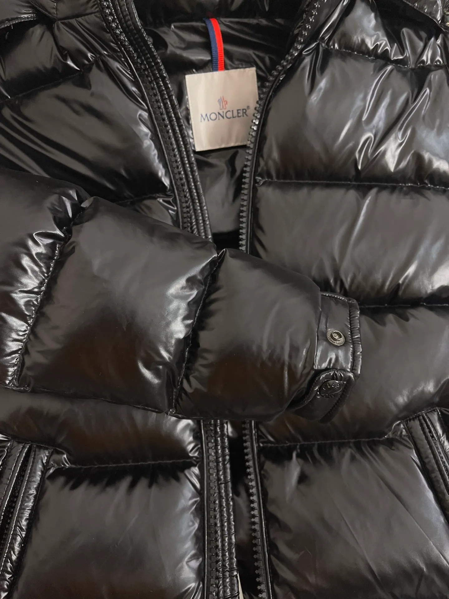 P1180 Moncler Maya Men's Men's Short Down Jacket The Moncler Maya men's down jacket is made of shiny patented nylon with signature rectangular quilting, which is a model of Moncler style. A classic cropped design that transcends seasons and styles, it features a statement silhouette, removable hood and adjustable hem. The sleeves are embellished with classic patch pockets, showcasing the brand's signature style.  Fabric: 100% nylon, 90% white goose down Craftsmanship: Made of lacquered nylon, lacquered nylon lining filled with down, rectangular quilting, detachable hood with snaps that can be adjusted by drawstring, two-way zip fly, external and internal zippered pockets, adjustable elastic cuffs with snaps, hood with drawstring, sleeves with flap patch pockets, sleeves decorated with Moncler felt trademark.  Size: 123456 0548000