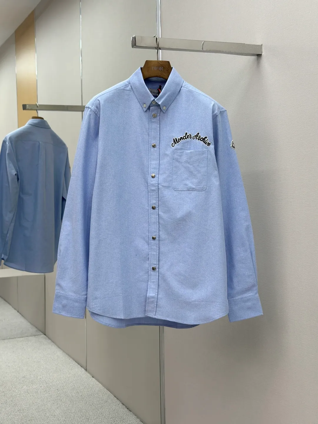 P420 Moncler logo embroidered Oxford cotton shirt. Custom-dyed moire pure cotton Oxford fabric. Soft and delicate like clouds. Use foggy gray tones of light blue as the pen to write the elegant color philosophy of the mountains on the pure cotton fabric. Taken from nature, higher than natural tonal design. The Moncler Archive embroidery embellishment on the chest. The seemingly casual handwriting embroidery is actually Moncler's attitude towards the brand. Find a balance between relaxation and stiffness. Every step is like interpreting the dance of the human body and clothing. Process 1: Adopting imported machine embroidery technology, using advanced computer control systems and precision mechanical components to achieve Moncler embroidery operations with high precision and smooth and delicate lines. Process 2: The fabrics are sand washed and have a better hand feel. Not easy to deform, not easy to shrink, not easy to fade, and maintain long-term beauty. Accessories: Customized Moncler snap buttons Customized Moncler buttons Customized Moncler trademark Version: Loose version Size: S M L XL