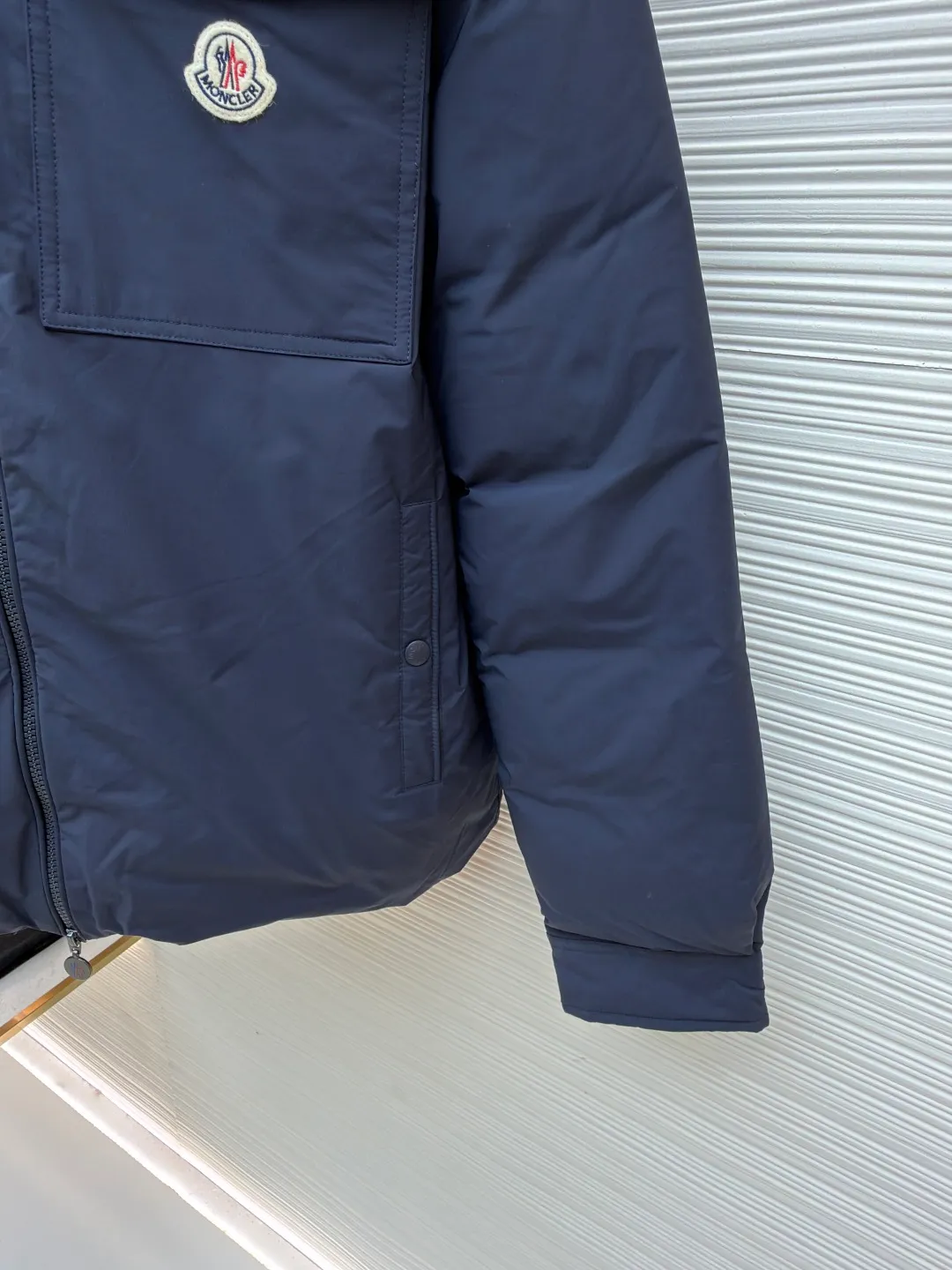 P910 Moncler lapel jacket style down jacket ●Original version: purchased and developed by 8273 ●Item number: 1681792-D15 ●Fabric: white duck down fabric ●Technology: mechanical down filling ●Color: navy blue ●Version: fitted version ●Weight: about 760 grams ●Size: 1-2-3-4 ●Description: The inner lining is made of 100% nylon. The high-density and tight weaving process prevents tiny lint from emerging from the gaps in the fabric. The smooth surface improves the putting on and taking off experience, and the excellent wear and tear resistance ensures damage caused by frequent use, while the light and soft texture does not affect the overall weight. It uses 90 white duck down with a weight of 200g to ensure excellent thermal insulation performance. After strict screening and processing, the down is not easy to drill, ensuring durability and using a neat shirt style. Compared with conventional down jackets, it is slimmer and more capable, and is suitable for business casual or various occasions. The interior uses a highly saturated orange lining, which brings a surprising visual impact when worn. The flap chest patch pocket located on the left chest is not only practical, but also greatly enhances the sophistication and recognition of the garment. The flip design can better protect the contents of the bag. The front of the clothing uses a smooth zipper as the main opening and closing method to ensure windproof warmth and easy putting on and taking off. The cuffs are opened and closed with buttons, which can accurately adjust the tightness of the cuffs to prevent cold wind from entering. At the same time, it perfectly echoes the overall shirt style and looks particularly elegant. The overall wiring is straight and delicate, the fabric is comfortable and soft, and the color is consistent without color difference. It can be matched with the same style to create a fashionable look and control various occasions. Customized accessories, complete with three standards, same style for men and women!