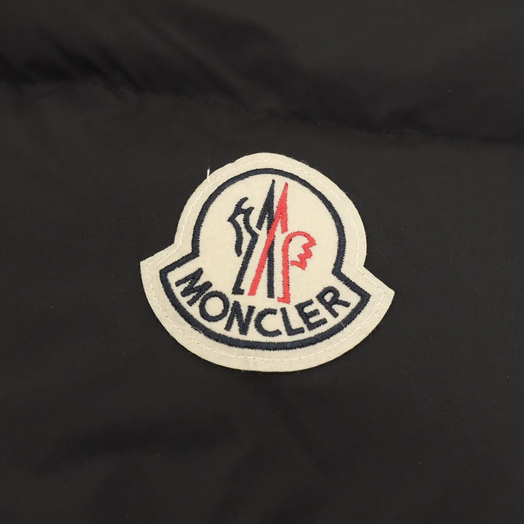 P1360 Moncler Bosona Mid-Length Large Felt Badge Down Jacket This Bosona men's long down jacket combines classic Moncler aesthetics with outstanding performance and protective features.  The Bosona long down jacket is made of longue saison fabric and is designed with practical details to provide both warmth and protection. As a Moncler classic, this down jacket features a detachable hood and a front zipper placket that covers the windshield, significantly improving its protective performance. Details •Made from longue saison fabric •Longue saison lining •Down filled •Removable hood •Zip and snap fastening •Zip pockets •Patch pockets on sleeves •Adjustable cuffs •Drawstring hem size:0-3