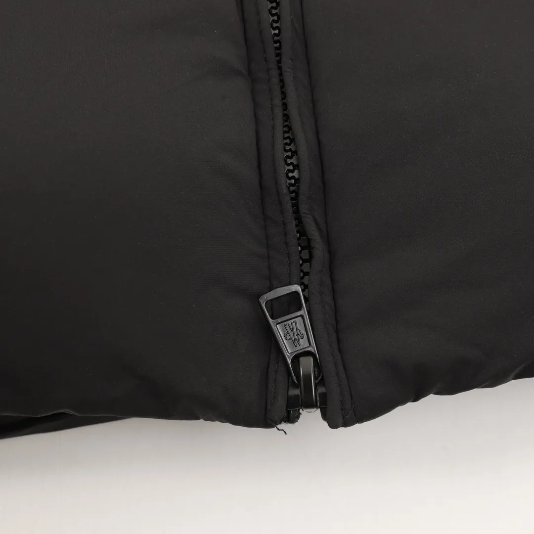 P1360 Moncler Bosona Mid-Length Large Felt Badge Down Jacket This Bosona men's long down jacket combines classic Moncler aesthetics with outstanding performance and protective features.  The Bosona long down jacket is made of longue saison fabric and is designed with practical details to provide both warmth and protection. As a Moncler classic, this down jacket features a detachable hood and a front zipper placket that covers the windshield, significantly improving its protective performance. Details •Made from longue saison fabric •Longue saison lining •Down filled •Removable hood •Zip and snap fastening •Zip pockets •Patch pockets on sleeves •Adjustable cuffs •Drawstring hem size:0-3