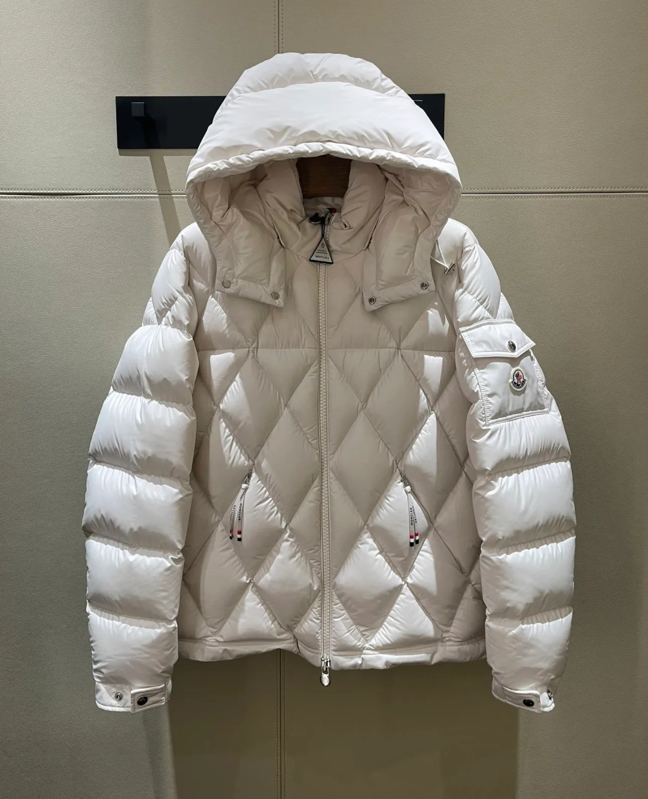 P840 Chiped Premium Down Moncler Averole Short Men's Diamond Check Down Jacket Jacket. Premium goose down filling. Original matching hardware. The Averole Men's Short Down Jacket features an eye-catching stitching pattern that combines diamond quilted yoke and long square quilted body. The Averole Men's Short Down Jacket features an eye-catching stitching pattern, diamond-quilted yoke and long checkered quilting throughout. Made from stretch nylon and features a removable hood, pockets and two-way zip fly. Details •Made from stretch nylon fabric •Stretch nylon lining •Down filling •Detachable and adjustable hood with press studs and drawstring •Diamond quilted yoke •Zip closure •Zip pockets •Adjustable cuffs with press studs •Fleece felt logo Size: 1-5 Black White