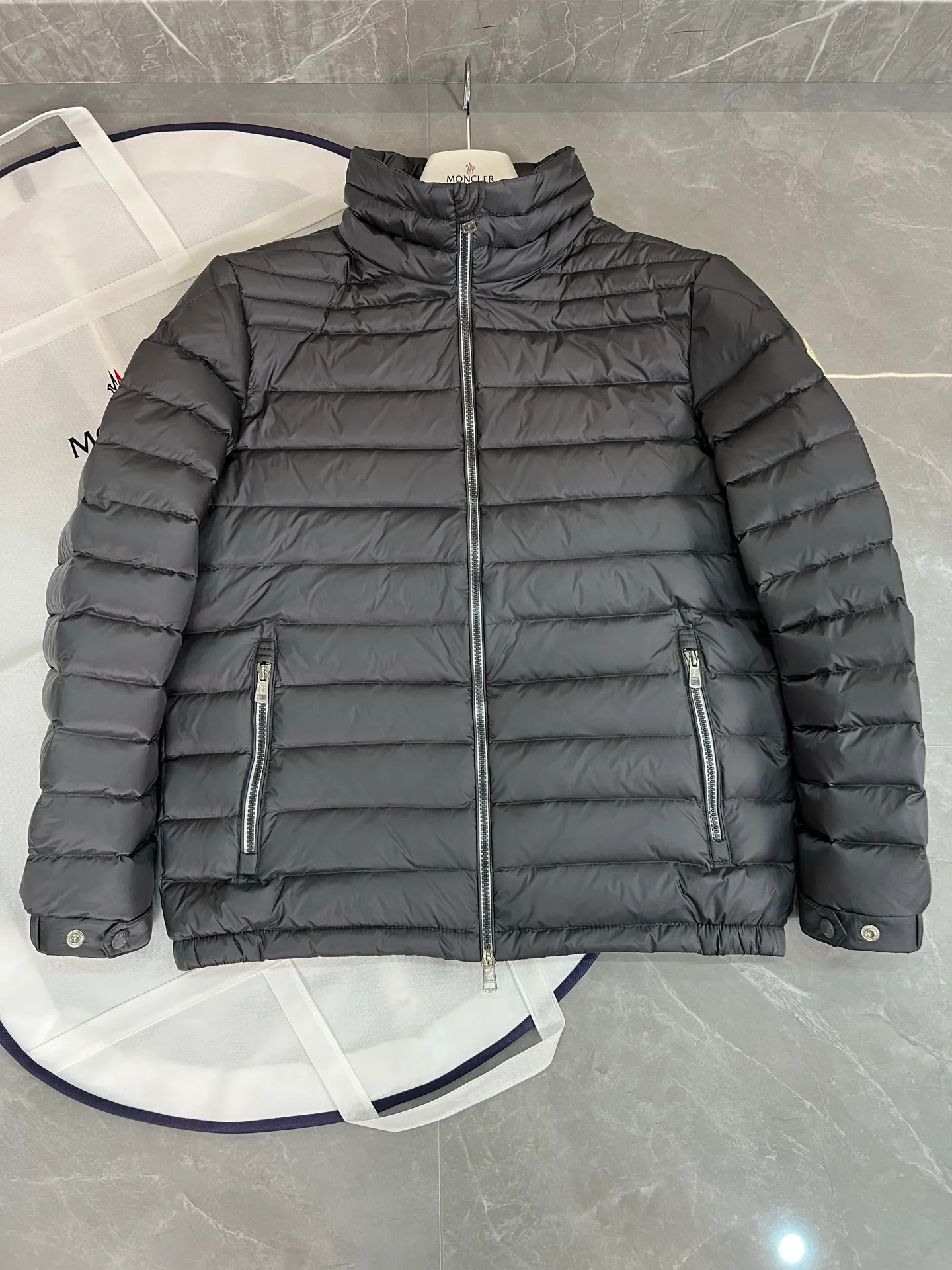 The Arnique hooded down jacket with polyester outer fabric is Moncler's classic men's design.   P780