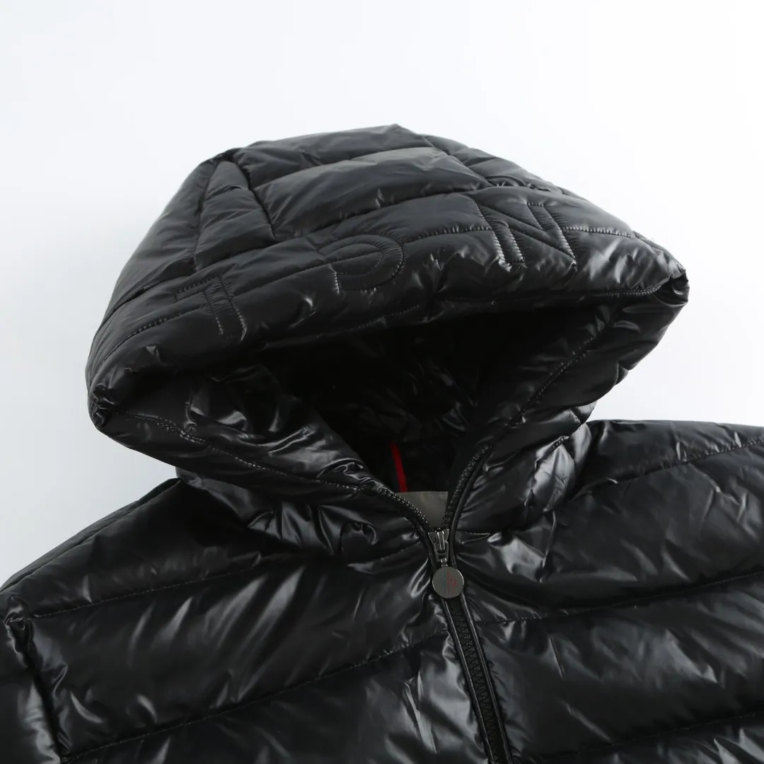 P900 MONCLER hooded brim quilted embroidered down jacket Fabric selection: The longue saison fabric is made of high-count polyamide fiber, which is known for its excellent tensile strength and lightness. Its good flexibility makes the fabric less prone to wrinkles and keeps it crisp and stylish for a long time. The tight weave effectively blocks the invasion of cold wind and locks in the warm air generated by the down layer. The high-density nylon surface forms a certain lotus leaf effect, making it difficult for small water droplets to penetrate, keeping the interior dry and effectively extending the service life of the down.  Lining selection: High-density lining fabric made of ultra-fine denier, 0.08mm thickness to avoid increasing the overall weight and making it smooth to wear. The high-density woven structure forms a wind resistance layer to protect the thermal efficiency of the thermal layer from loss. It can also withstand the expansion pressure of down and prevent deformation and damage after long-term use.  Technology: The quilted letter logo on the brim uses contour quilting technology. The stitching is routed along the edge of the set outline, and the filler is compressed inside the letter graphic, so that the logo is three-dimensional and convex, and the pattern is clear.  High-quality filling: It is filled with 90% selected white duck down, weighing 210g, ensuring fluffy rebound, lightness and warmth.  Accessories: one-to-one customized zipper pendant, one-to-one customized badge, one-to-one customized three-label SIZE: 1 2 3 4